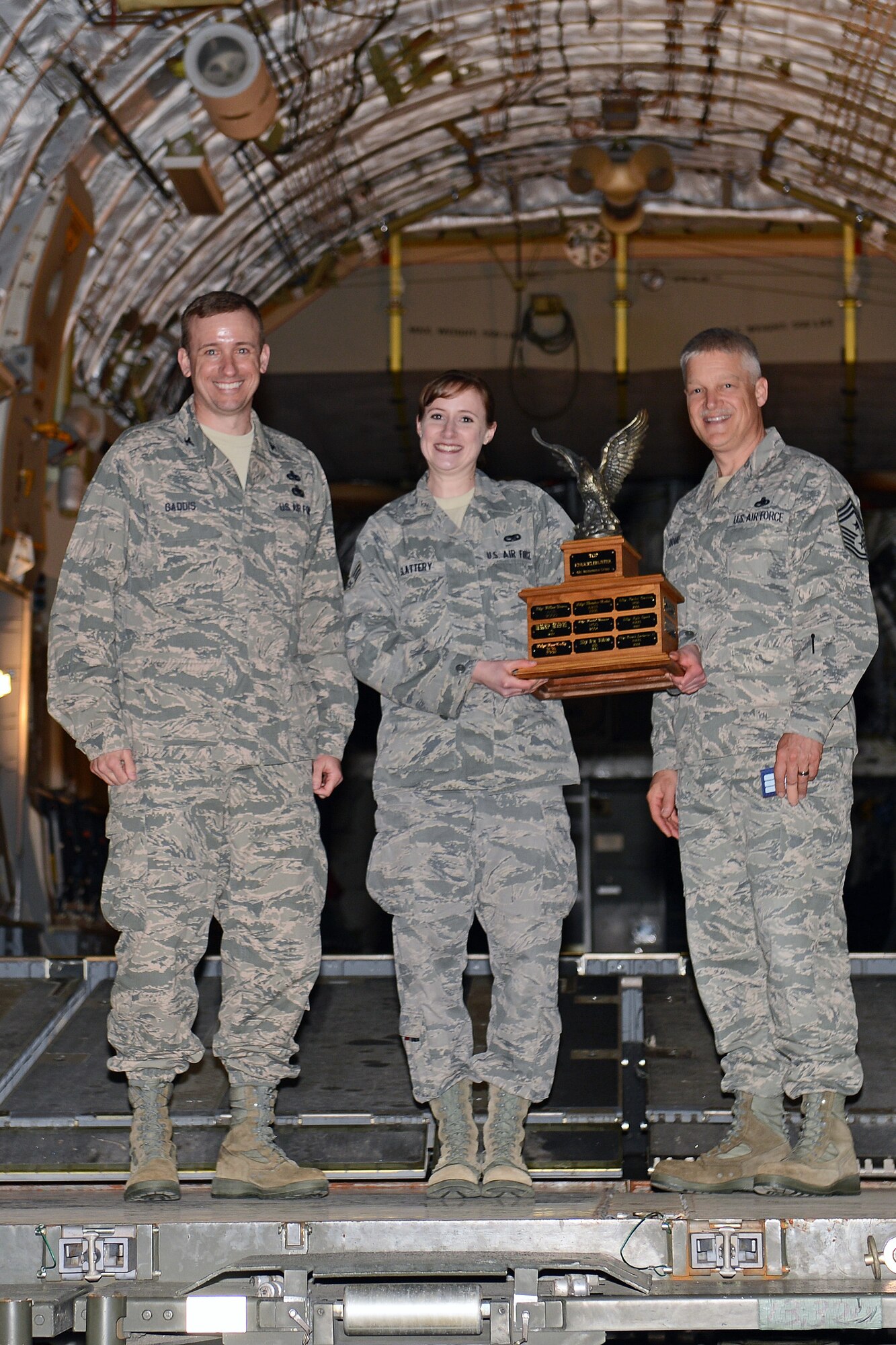 Col. Craig Gaddis (left), 62nd Maintenance Group commander, Senior Airman Tiffany Slattery (center), 62nd Aircraft Maintenance Squadron hydraulics specialist, and Chief Master Sgt. Gordon Drake (right), 62nd Airlift Wing command chief, pose for photos during LogFest April 4, 2014 at Joint Base Lewis-McChord, Wash. Slattery was awarded the 62nd MXG’s Top Knucklebuster award, an award given to the 62nd MXG’s highest performing Airman. (U.S. Air Force photo by Airman First Class Jacob Jimenez)
