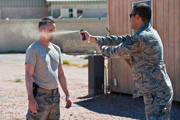 Staff Sgt. Jordan Young, right, 99th Security Forces Squadron training instructor administers pepper spray to Staff Sgt. Anthony Dykhuis, 99th SFS unit training manager, April 1, 2014, at Nellis Air Force Base, Nev.  The level one inoculation pepper spray training enhances
the capability of SF members in the field.  The 99th SFS earned the 2013 Air Force outstanding large security forces unit award. (U.S. Air Force photo by Senior Airman Christopher Tam)
