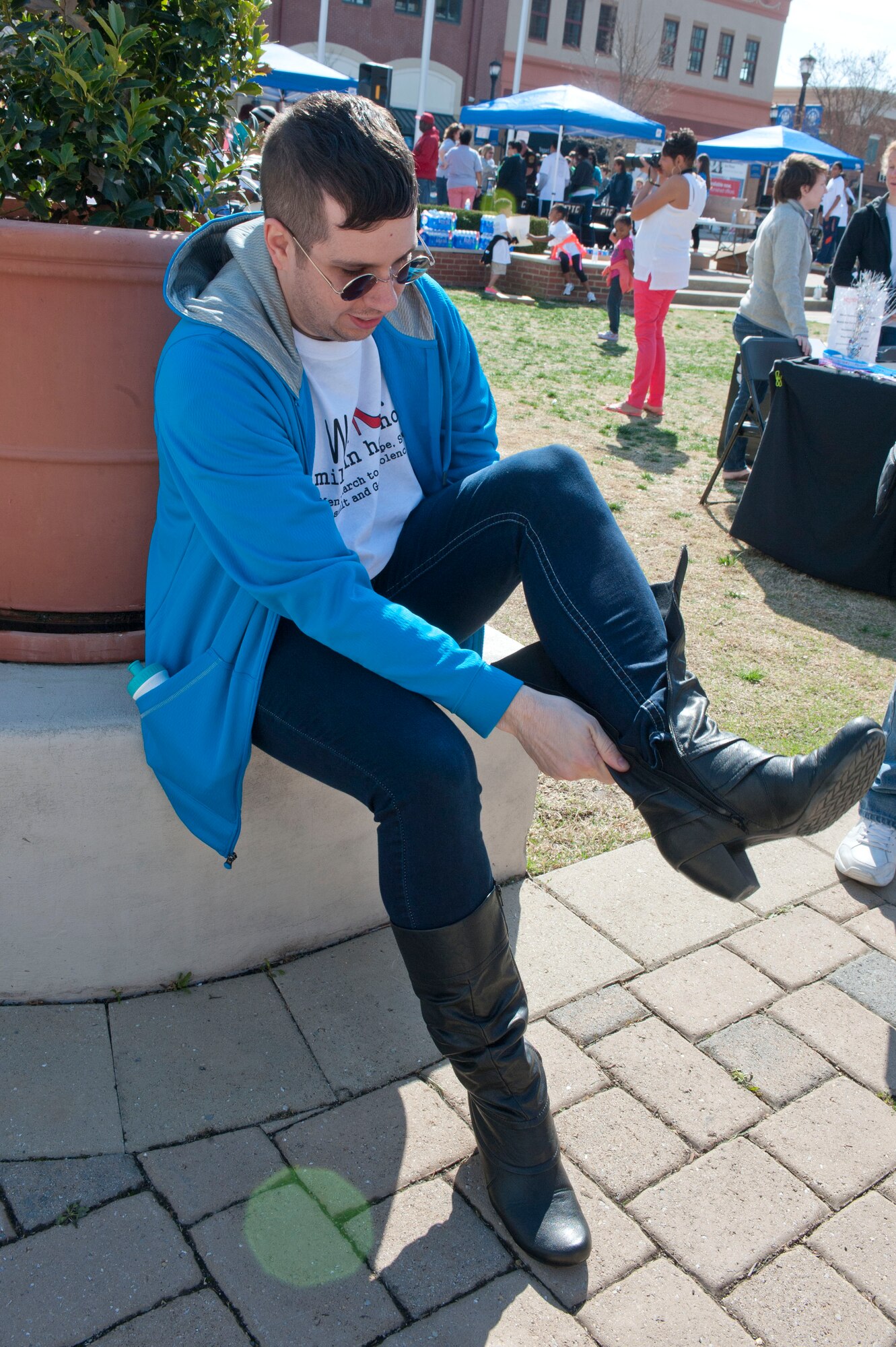 Senior Airman Jacob Bryant, 633rd Communication Squadron network technician, puts on his high heels during Walk a Mile in Her Shoes in Hampton, Va., April 5, 2014. This is Bryant’s second year attending the walk that supports Sexual Assault Awareness Month. (U.S. Air Force photo by Staff Sgt. Stephanie Plichta/Released) 