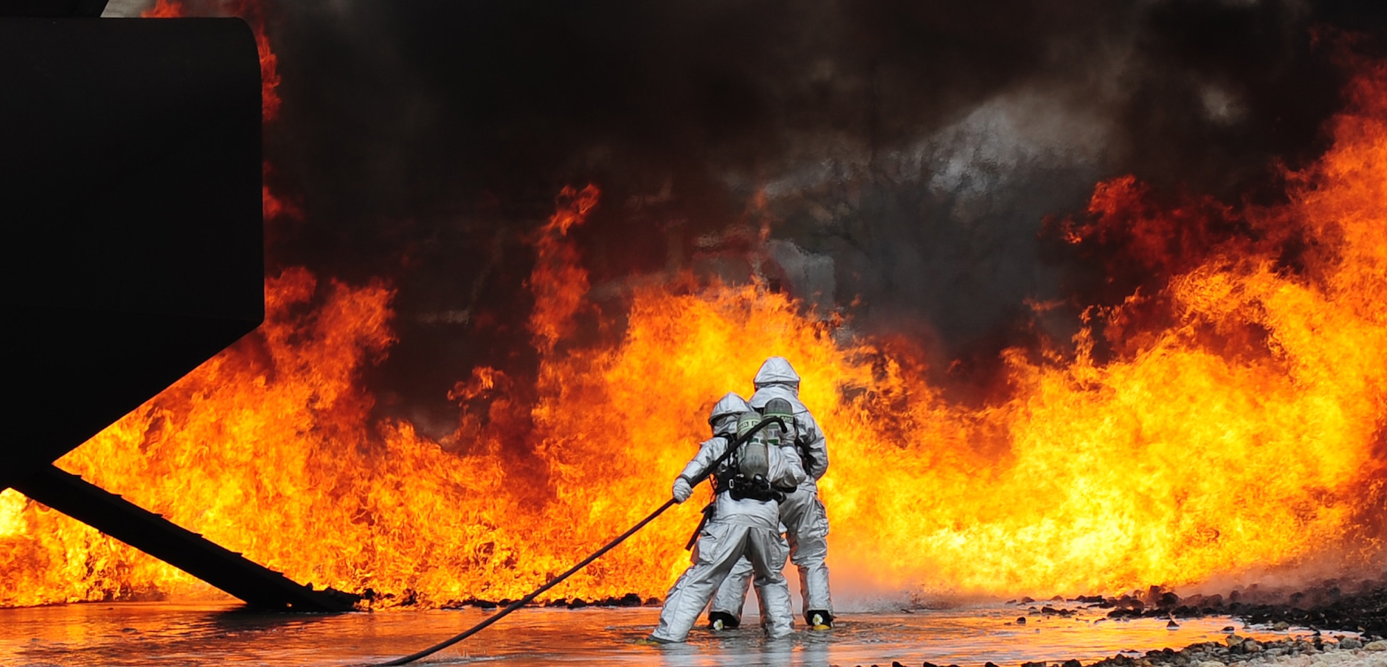 U.S. Air Force firefighters from the 7th Civil Engineer Squadron participate in live fire training exercise April 2, 2014, at Dyess Air Force Base, Texas. Teams from the Dyess Fire Department and Abilene Regional Airport Fire Department demonstrated various hose and firefighting procedures while engaging the controlled blaze. (U.S. Air Force photo by Senior Airman Kia Atkins/Released)