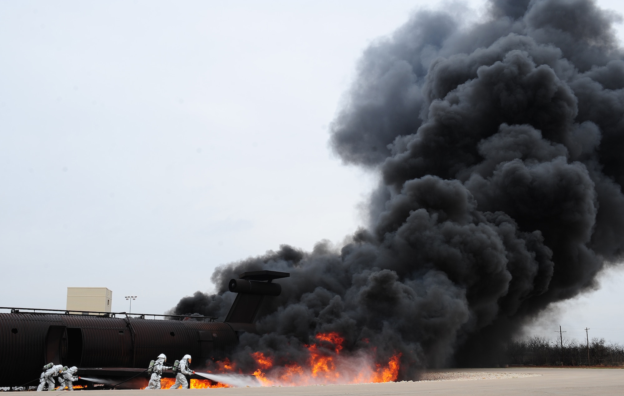 U.S. Air Force firefighters from the 7th Civil Engineer Squadron participate in live fire training exercise April 2, 2014, at Dyess Air Force Base, Texas. Teams from the Dyess Fire Department and Abilene Regional Airport Fire Department demonstrated various hose and firefighting procedures while engaging the controlled blaze. (U.S. Air Force photo by Senior Airman Kia Atkins/Released)