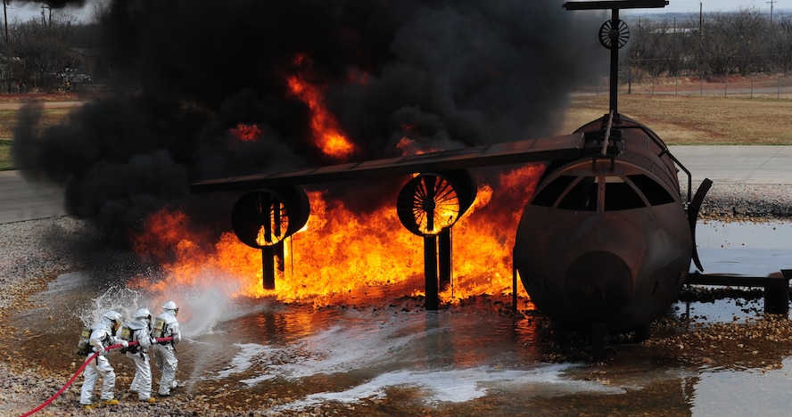 Firefighters from the Abilene Regional Airport Fire Department extinguish a fire during live fire training exercise April 2, 2014, at Dyess Air Force Base, Texas. Upon ignition, jet fuel starts to burn at 410 degrees Fahrenheit and can reach temperatures over 1,800 degrees. (U.S. Air Force photo by Senior Airman Kia Atkins/Released)