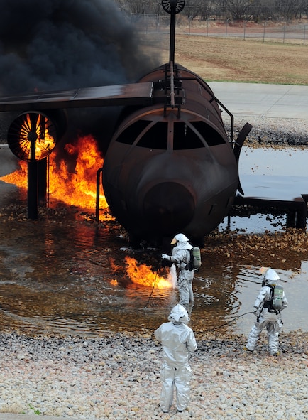 U.S. Air Force firefighters from the 7th Civil Engineer Squadron light a fire during a live fire training exercise April 2, 2014, at Dyess Air Force Base, Texas. During this live fire training, jet fuel was used to simulate the same type of fire that firefighters would encounter during an actual aircraft emergency.  (U.S. Air Force photo by Senior Airman Kia Atkins/Released)