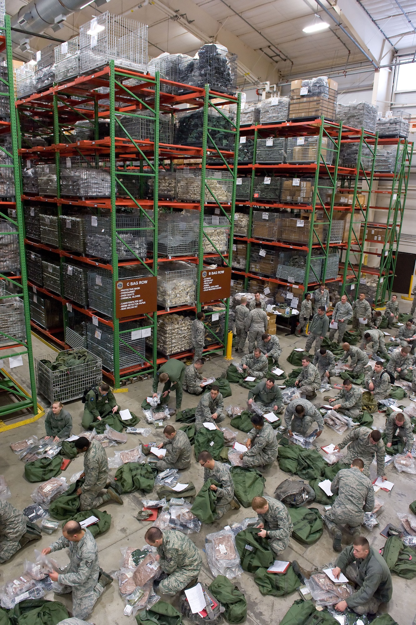 Team Dover members inventory items in their issued deployment bags April 4, 2014, at the deployment processing line on Dover Air Force Base, Del. Personnel from the 436th Logistics Readiness Squadron deployment line processing section assisted deploying personnel inventory two deployment bags issued to them as part of a deployment exercise. (U.S. Air Force photo/Roland Balik)