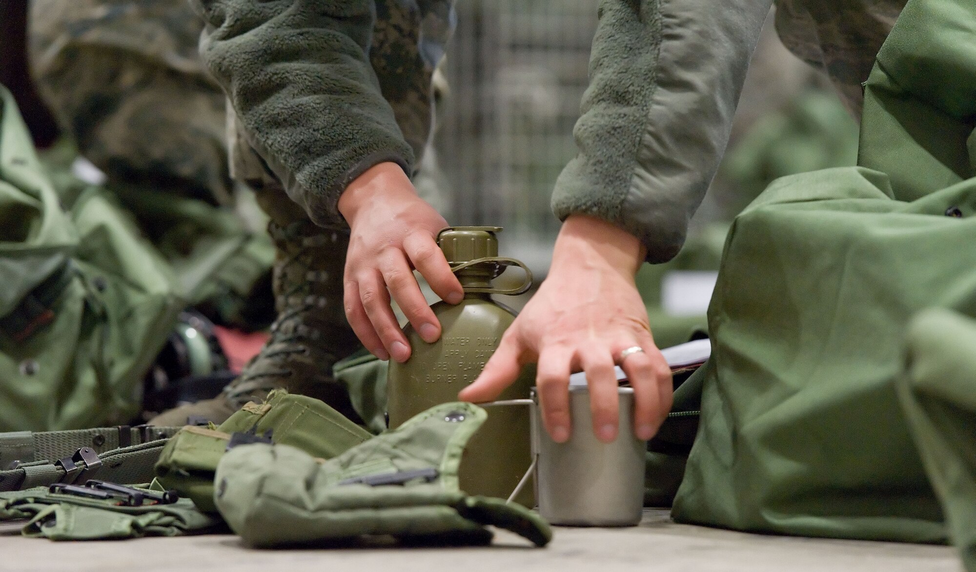 A Team Dover member reaches for deployment bag items April 4, 2014, at the deployment processing line on Dover Air Force Base, Del. Personnel thoroughly inventoried two deployment bags issued to them during the inaugural East Coast Combat Operations exercise. (U.S. Air Force photo/Roland Balik)