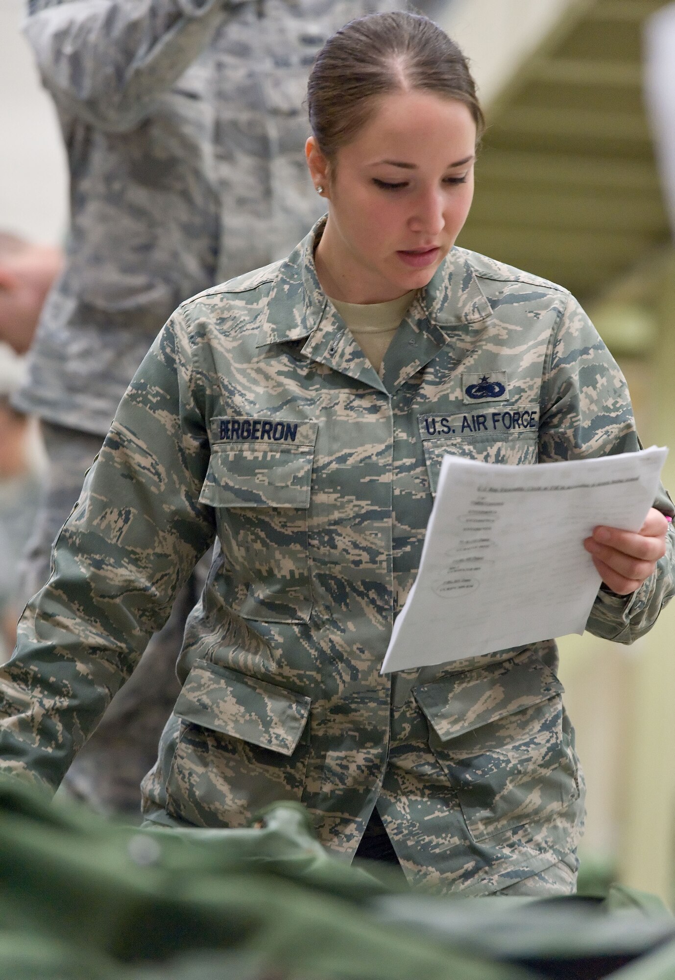 Staff Sgt. Samantha Bergeron, 436th Logistics Readiness Squadron, reads listed items for one of her deployment bags April 4, 2014, at the deployment processing line on Dover Air Force Base, Del. Bergeron and other Team Dover members took part in a deployment exercise to test the deployment preparedness of Dover AFB. (U.S. Air Force photo/Roland Balik)