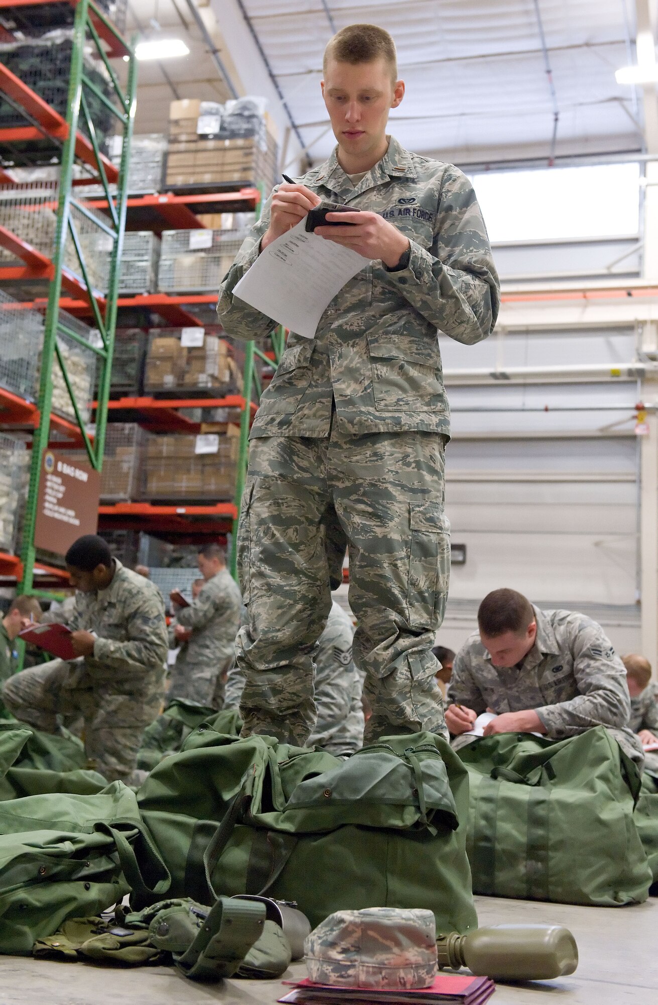 Second Lt. Steven Cooper, 436th Civil Engineer Squadron requirements and optimization chief, reviews his deployment bag items April 4, 2014, at the deployment processing line on Dover Air Force Base, Del. Cooper and other Team Dover members thoroughly checked two deployment bags issued to them during deployment line processing. (U.S. Air Force photo/Roland Balik)