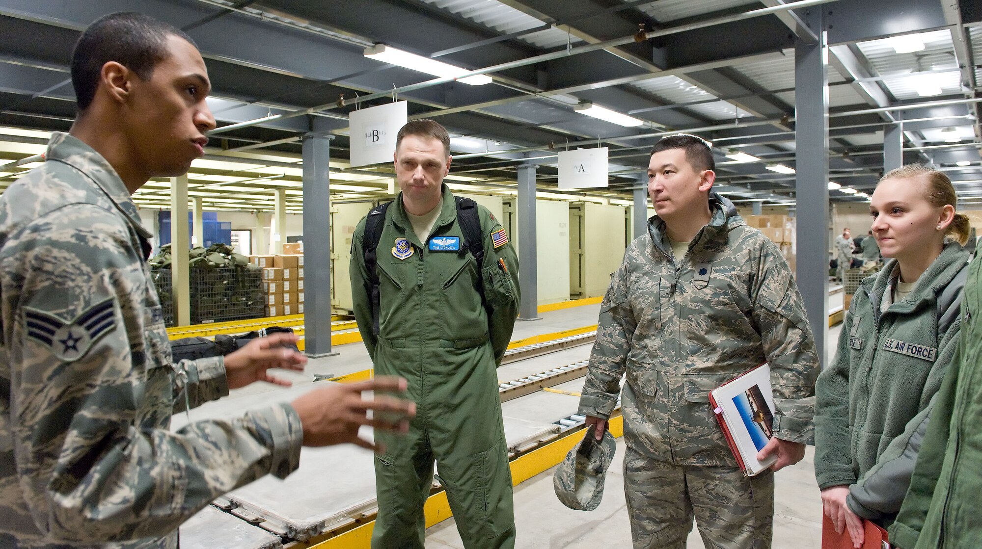 Senior Airman Joshua Hernandez, left, 436th Logistics Readiness Squadron individual protective equipment journeyman, briefs Team Dover members April 4, 2014, at the deployment processing line on Dover Air Force Base, Del. Hernandez briefed personnel on the process for acquiring deployment bags. (U.S. Air Force photo/Roland Balik)