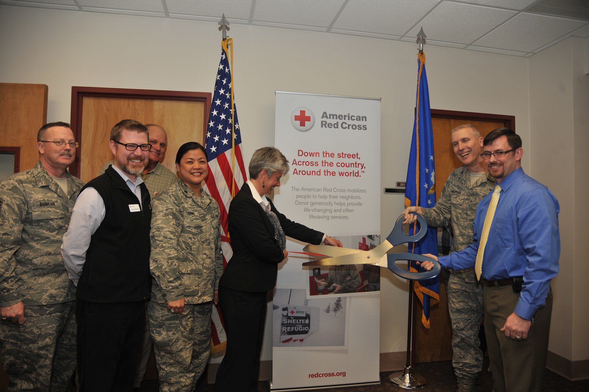 Col. Paul Bauman, 319th Air Base Wing commander (right), Johnny Adams, 319th Medical Group volunteer coordinator and Judy Green, American Red Cross Dakotas Region CEO, cut the ribbon for the opening of the Red Cross volunteer office on April 4, 2014, at the 319th Medical Group facility on Grand Forks Air Force Base, N.D. The Red Cross volunteer program was opened to provide medical support services for U.S. military members, veterans and their families. (U.S. Air Force photo/Senior Airman Xavier Navarro)