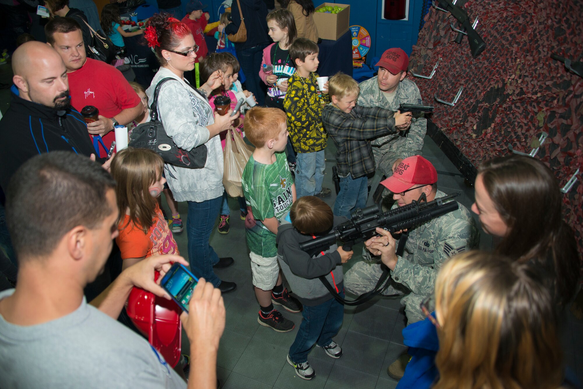 Members of Security Forces Combat Arms supervise a showcase of weapons for Keesler children and personnel during Child Pride Day April 5, 2014, at the Youth Center, Keesler Air Force Base, Miss.  Child Pride Day is an annual event in collaboration with the month of the military child. (U.S. Air Force photo by Adam Bond)  (U.S. Air Force photo by Adam Bond)