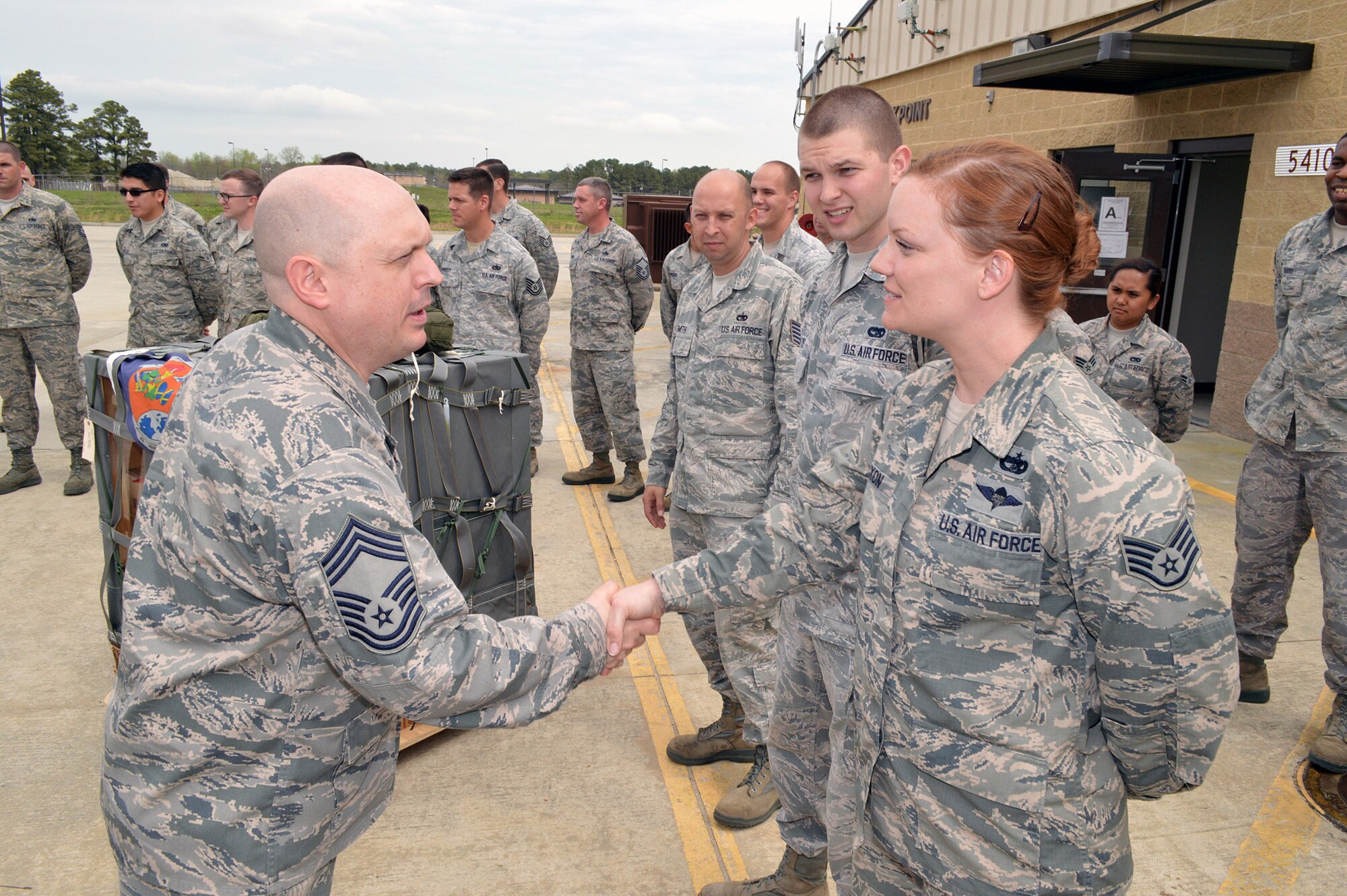Chief Master Sgt. Michael T. O’Donnell, Air Mobility Command chaplain assistant functional manager, shakes hands with Staff Sgt. Christine A. Mixon, 3rd Aerial Port Squadron, during he and Col. E. Mark Barnes, Air Mobility Command chaplain’s visit to the 3rd Aerial Port Squadron on Apr 8, 2014, Pope Army Airfield, Fort Bragg, N.C. The 3rd Aerial Port squadron serves as the primary supporter of the XVIII Airborne Corps, as well as the 82d Airborne Division and their Global Response Force mission. Port Airmen have also been a constant force multiplier in Afghanistan and Iraq. The aerial porters bring superior job knowledge, skill and leadership to the U.S. Central Command’s area of responsibility. (U.S. Air Force photo/Marvin Krause)