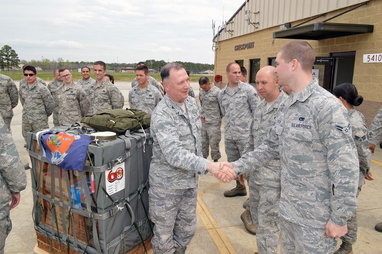 Col. E. Mark Barnes, Air Mobility Command chaplain, left, shakes hands with Airman 1st Class Frederick D. Smith, 3rd Aerial Port Squadron, during Barnes and Chief Master Sgt. Michael T. O’Donnell, Air Mobility Command chaplain assistant functional manager’s visit to the 3rd Aerial Port Squadron on Apr 8, 2014, Pope Army Airfield, Fort Bragg, N.C. The 3rd Aerial Port squadron serves as the primary supporter of the XVIII Airborne Corps, as well as the 82d Airborne Division and their Global Response Force mission. Port Airmen have also been a constant force multiplier in Afghanistan and Iraq. The aerial porters bring superior job knowledge, skill and leadership to the U.S. Central Command’s area of responsibility. (U.S. Air Force photo/Marvin Krause)