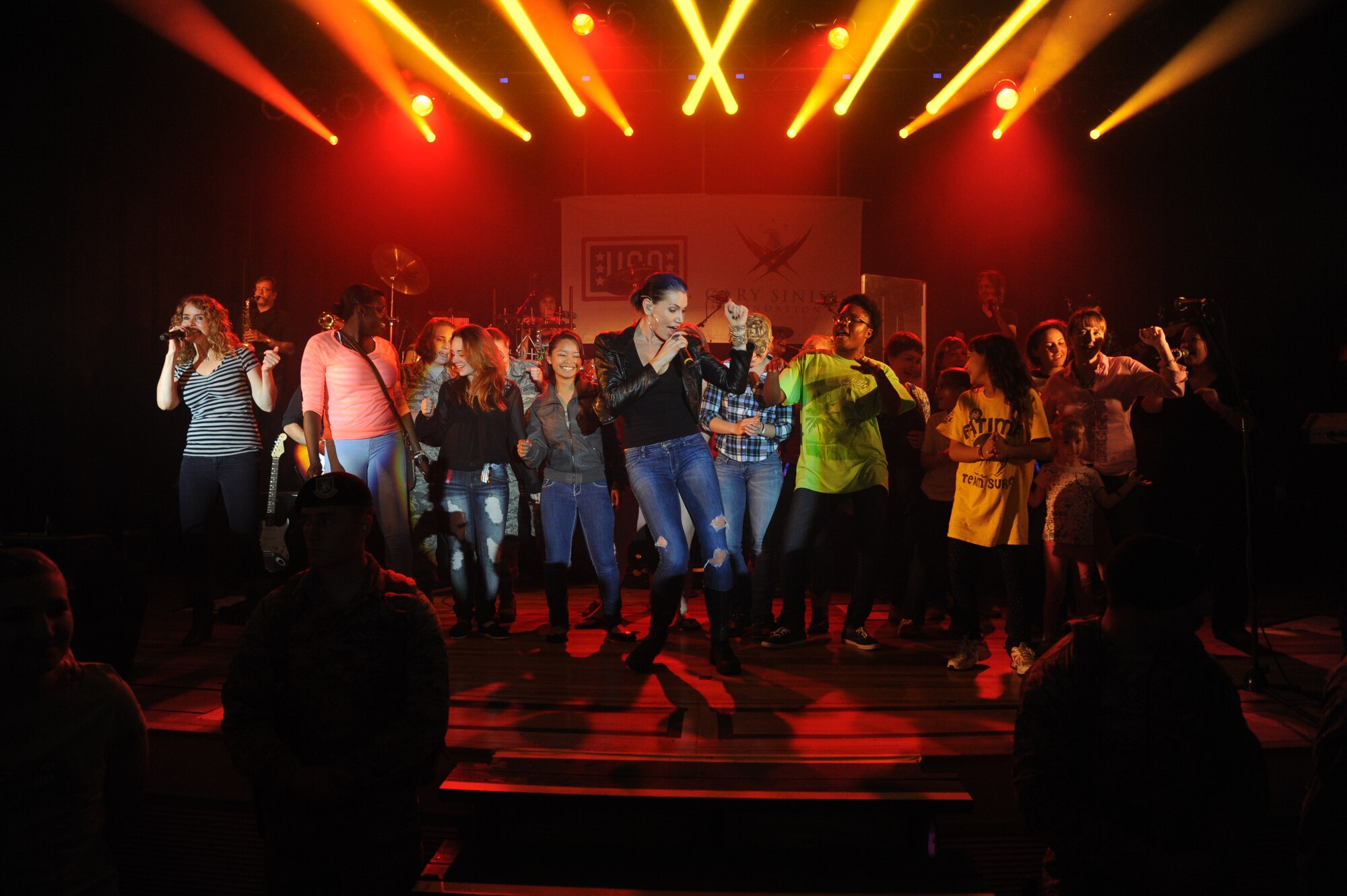 Molly Callinan of Gary Sinise & the Lt. Dan Band sings on stage with ladies of Keesler during a concert April 4, 2014, at the Welch Theater, Keesler Air Force Base, Miss.  The band visited Keesler during their morale-boosting 2014 USO tour of U.S. military bases.  They are also a program of the Gary Sinise Foundation, a nonprofit organization that supports and honors national defenders, veterans and first responders. (U.S. Air Force photo by Kemberly Groue)