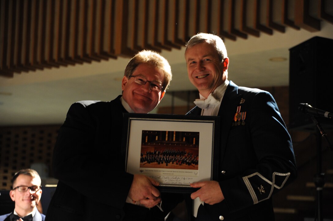 Col. Larry Lang presents Jeff Doebler with a memento during the U.S. Air Force Band’s 2014 Spring Concert Tour at Valparaiso University in Valparaiso, Ind., April 7, 2014. Doebler, the Valparaiso University director of bands, joined the Band on stage as a guest conductor during the program. Lang, a native of El Paso, Texas, is the Band commander and conductor. (U.S. Air Force photo/Master Sgt.  Tammie Moore) 