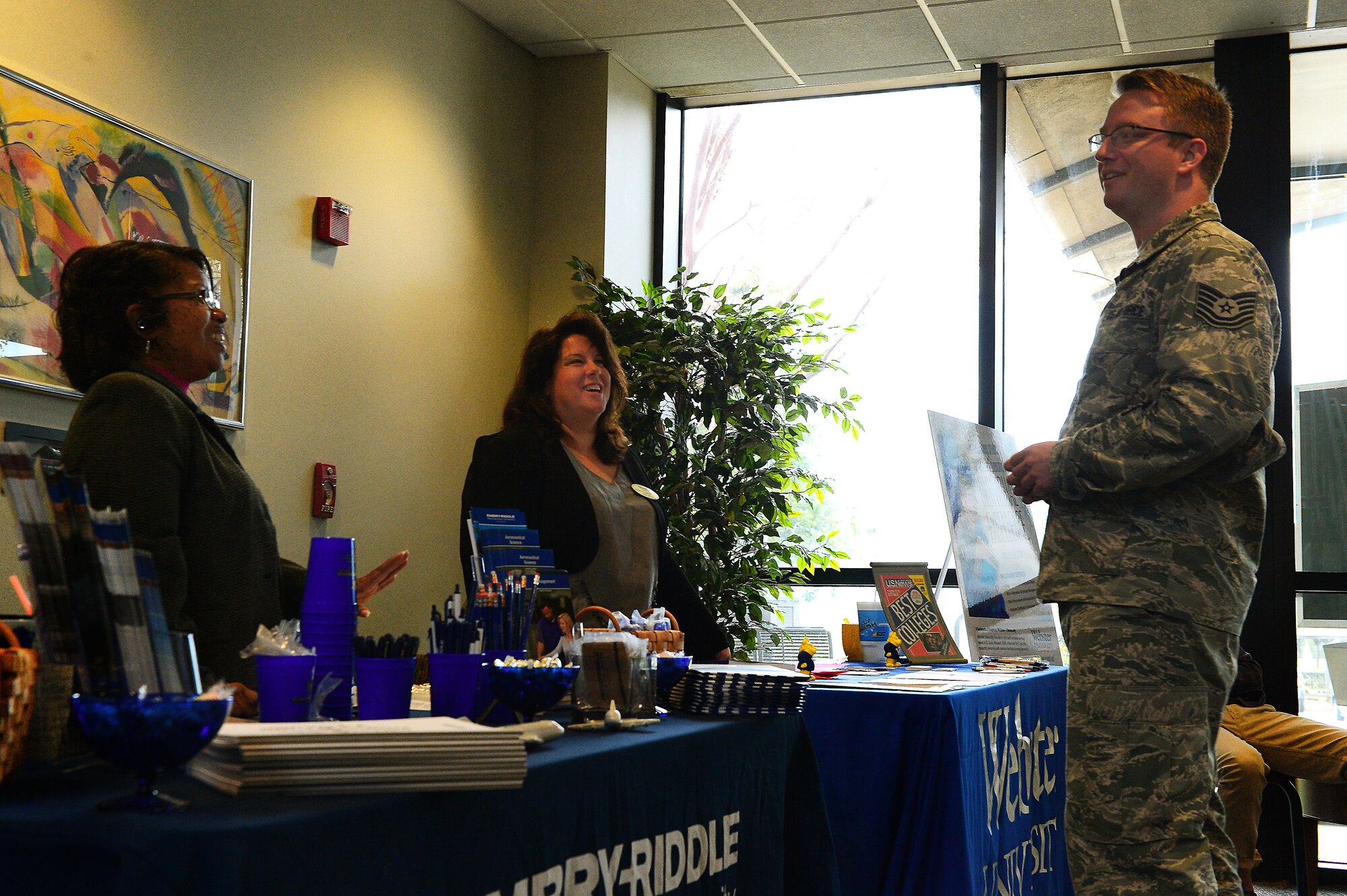 U.S. Air Force Tech. Sgt. Joshua Burrows, U.S. Air Forces Central NCO in charge of operations and internal law, speaks with college representatives at the Spratt Education Center at Shaw Air Force Base, S.C., April 8, 2014. Five schools participated in the education fair to inform Airmen and soldiers about what college programs are offered to service members. (U.S. Air Force photo by Airman 1st Class Jensen Stidham/Released)