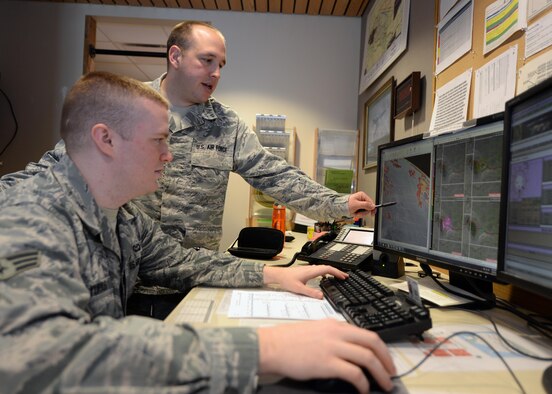 Tech. Sgt. Will Price, 28th Operations Support Squadron Weather Flight NCO in charge of mission integration function, works with Senior Airman Shane Yurkus, 28th OSS Weather Flight forecaster, to analyze weather patterns at Ellsworth Air Force Base, S.D., April 5, 2014. The Weather Flight uses satellite, radar, real time data, and model data to provide weather predictions for the base. (U.S. Air Force photo by Airman 1st Class Rebecca Imwalle /Released)