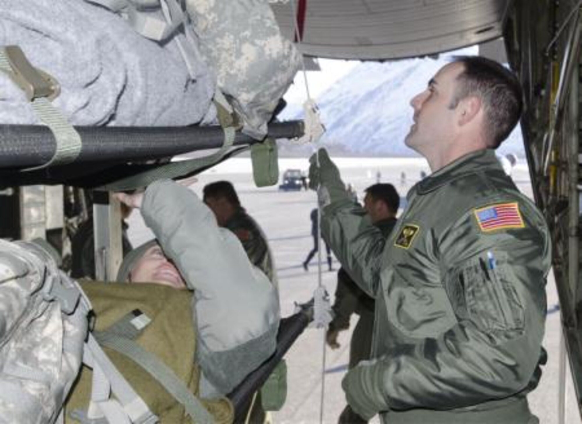 Tech Sgt. Mike Nagel, medical technician with the 146th Aeromedical Evacuation Squadron out of Channel Island Air National Guard Station, Calif., interacts with role-playing patients while conducting patient evacuations during Alaska Shield 14 here, March 31, 2014. The Air National Guard worked closely with the Army National Guard to conduct the training, which took place on a C-130 Hercules. Alaska Shield 14 is an exercise that involves federal, state, local and military agencies, designed to test response and coordination efforts during a disaster and is modeled after the 1964 earthquake and subsequent tsunami that devastated much of South Central Alaska including the city of Valdez. (U.S. Army photo by Spc. True Thao)