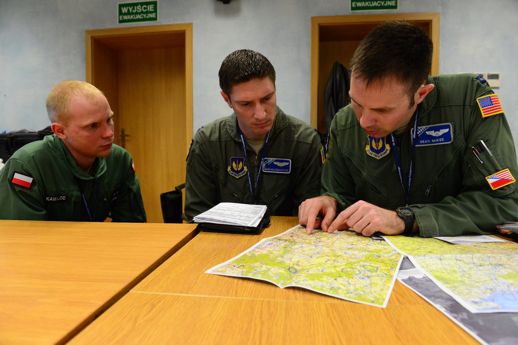 United States Air Force Capt. Sean McKee of the 37th Airlift Squadron, Ramstein Air Base, Germany, U.S. C-130J Super Hercules pilot, conducts a mission brief with his co-pilot and Polish counterpart, Polish Air Force 1st Lt. Szymon Vawalec, at Powidz Air Base, Poland, April 2, 2014. During an aircraft rotation at the U.S. Aviation Detachment in Poland, allied forces worked together to increase interoperability through various exercises, including static-line and high altitude low-level jumps, container delivery system bundle drops, grass-strip tactical landings and observation flights.  (U.S. Air Force Photo/Tech. Sgt. Daylena S. Ricks/Released)