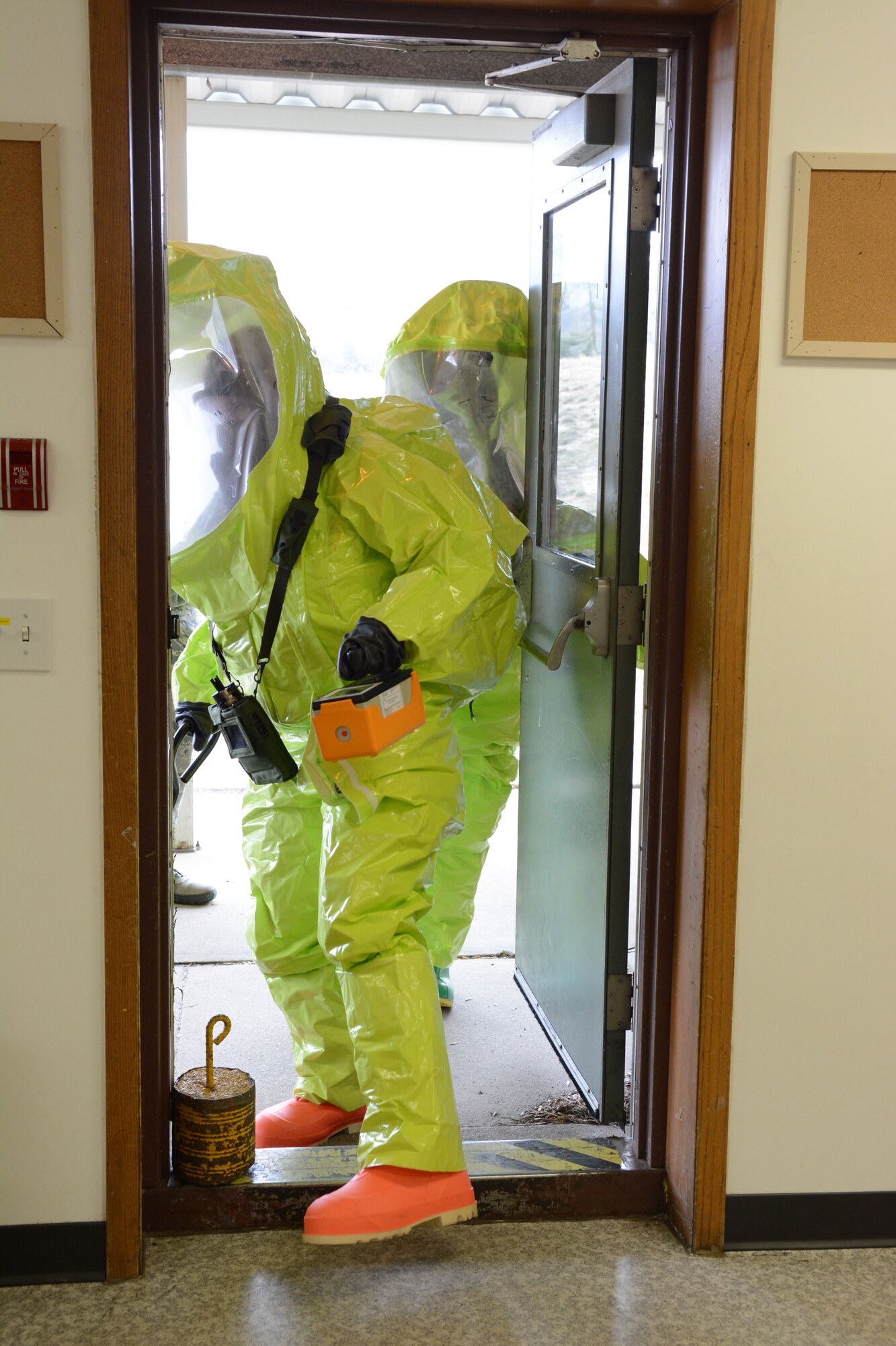 Senior Airman Elisabeth Adkins, 934th emergency management, and Master Sgt. Laura Valente, 183rd emergency management enter the facility during a field training exercise at Volk Field Air National Guard Base, Wis., April 4, 2014. Their goal was to scan the facility for anything suspicious and document everything they saw so that teams going in after they came out could be more prepared for the biological, chemical or radiation situations inside. The training was part of emergency management’s annual training requirement. (Air National Guard photo by Senior Airman Andrea F. Liechti)