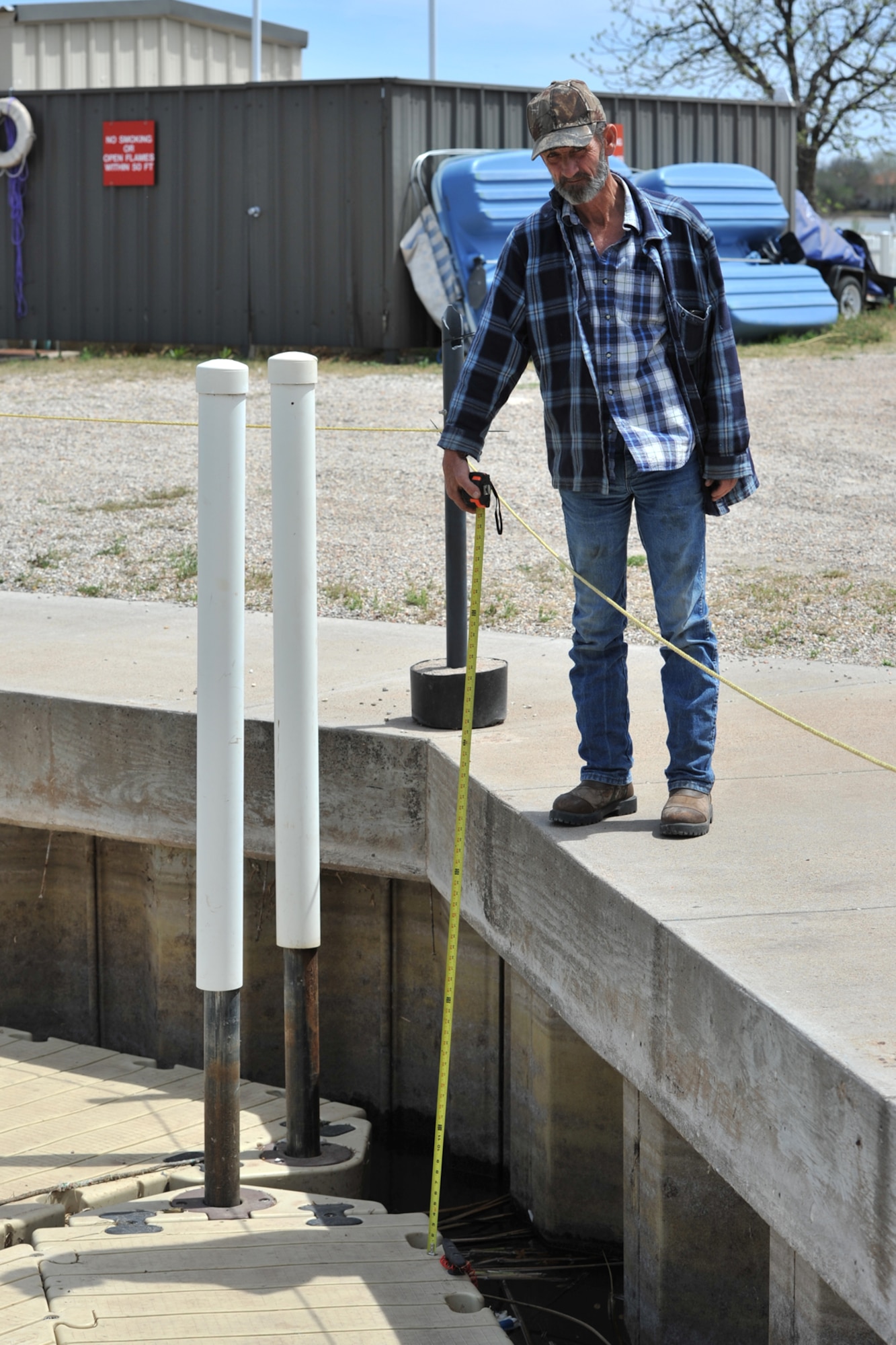SAN ANGELO, Texas – Harry F. Gilbert, Goodfellow Air Force Base Recreation Camp director, measures the water depth at Lake Nasworthy April 4. The water level was more than 40 inches below the average depth. (U.S. Air Force Photo/ Airman 1st Class Devin Boyer)