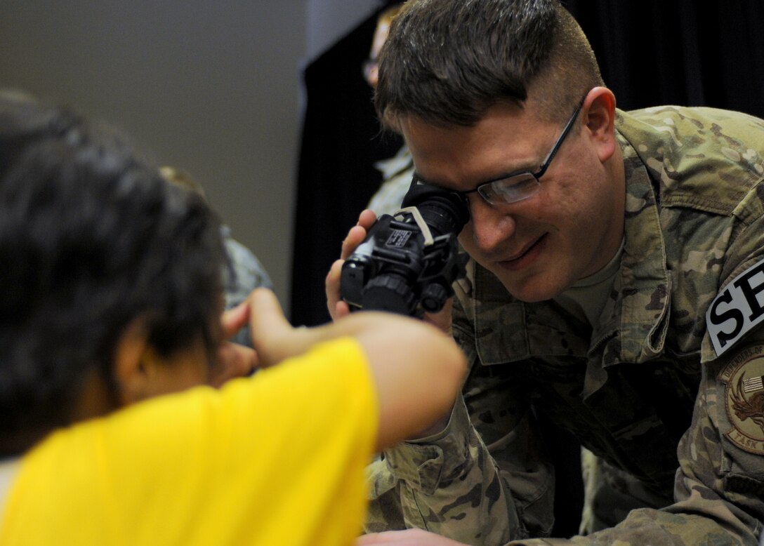 Staff Sgt. Evan Farmer, 28th Security Forces Squadron flight chief, demonstrates how to use night vision equipment to an area youth during the South Dakota School of Mines & Technology Cultural Expo in Rapid City, S.D., March 29, 2014. Ellsworth Airmen from several squadrons volunteered to represent their units and career fields during the two-day event focused on diversity and culture. (U.S. Air Force photo by 2nd Lt. Rachel Allison/Released)