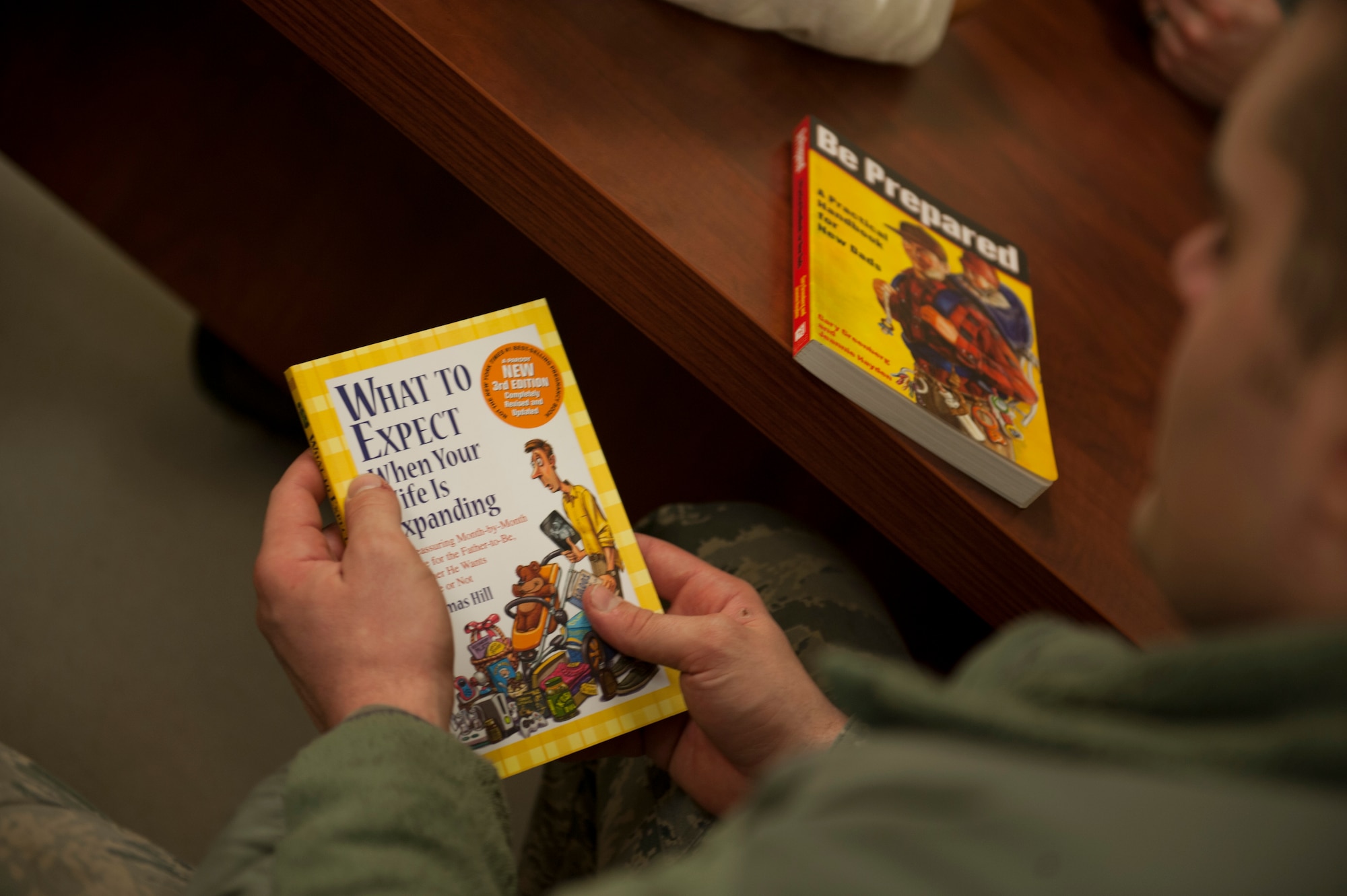 U.S. Air Force Senior Airman Grant Hanson, crew chief from the 5th Munitions Squadron, receives a new-father guide during a Dad’s 101 class on Minot Air Force Base, N.D., April 1, 2014. The Dad’s 101 class provided reading material for participants to help prepare them for their first child. (U.S. Air Force photo/ Airman 1st Class Sahara L. Fales)
