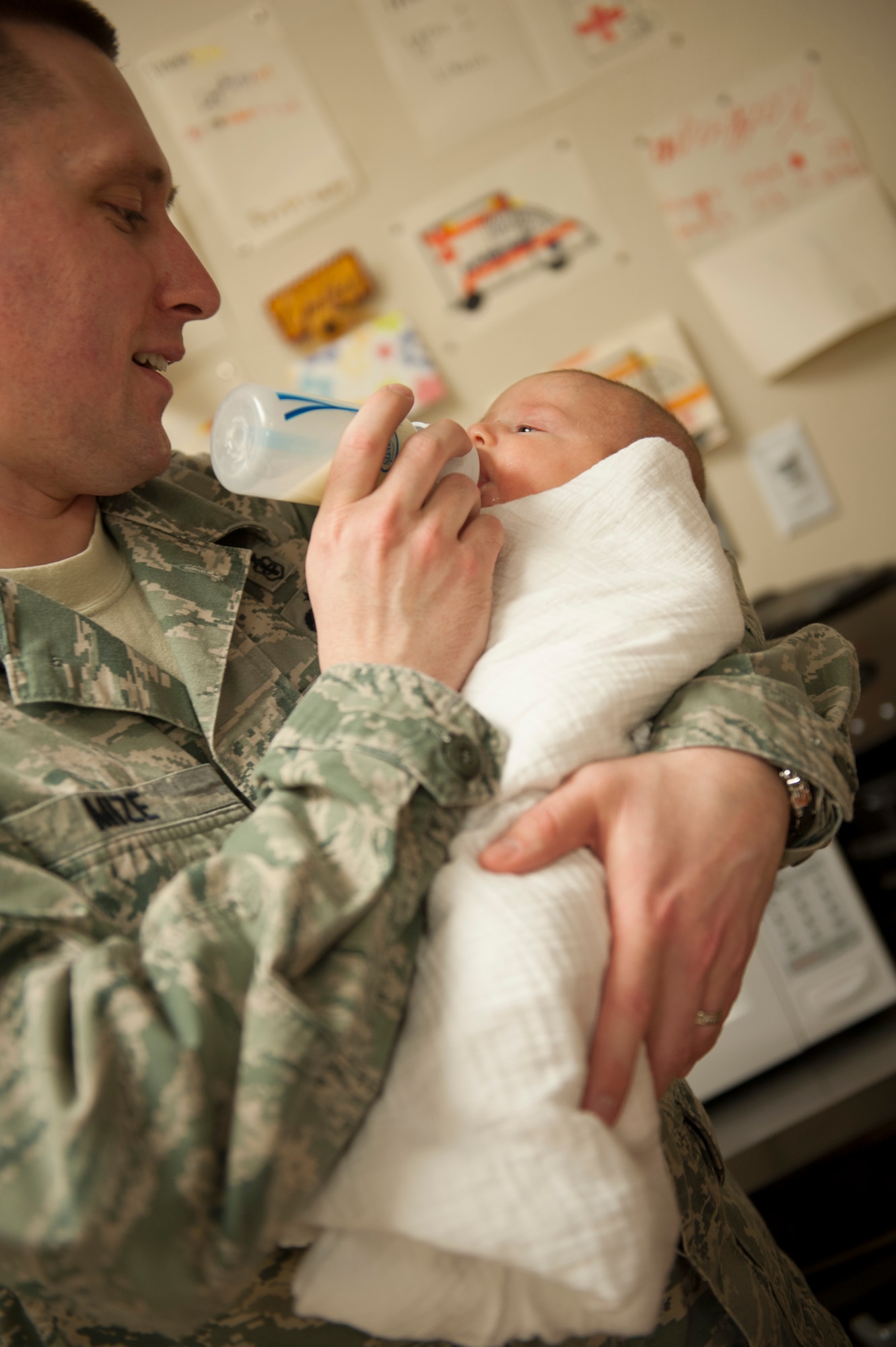 U.S. Air Force Tech. Sgt. Dustin Mize, NCO in charge of ambulance services from the 5th Medical Group, holds his nine-week-old daughter, Ashlyn, during a Dad’s 101 class on Minot Air Force Base, N.D., April 1, 2014. After teaching the swaddling technique, Mize demonstrated how to soothe and feed a newborn baby. (U.S. Air Force photo/ Airman 1st Class Sahara L. Fales)