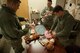 U.S. Air Force Tech. Sgt. Dustin Mize, NCO in charge of ambulance services from the 5th Medical Group, watches over soon-to-be fathers on Minot Air Force Base, N.D., April 1, 2014. The fathers practiced clothing, swaddling and changing diapers on dolls in preparation for their newborns. (U.S. Air Force photo/ Airman 1st Class Sahara L. Fales)