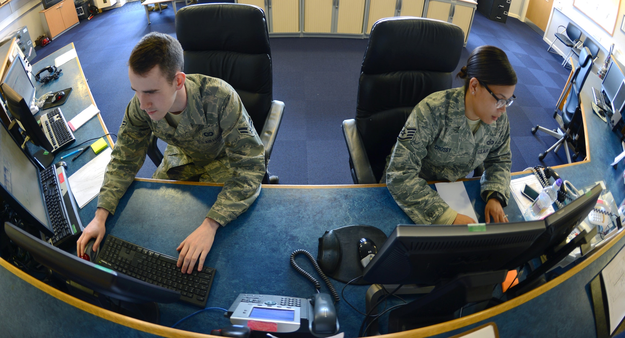 U.S. Air Force Airman 1st Class Keith Cottrell, left, 100th Operations Support Squadron airfield management operations coordinator from Beckley, W.V., updates the airfield status display while U.S. Air Force Staff Sgt. Shanara Crosby, 100th OSS airfield management operations supervisor from Greenville, S.C., reviews flight plans April 8, 2014, on RAF Mildenhall, England. Airfield management operations personnel are responsible for making sure the airfield is safe and clear of foreign object debris, as well as reporting defects on the runway surface. (U.S. Air Force photo by Airman 1st Class Dillon Johnston/Released)
