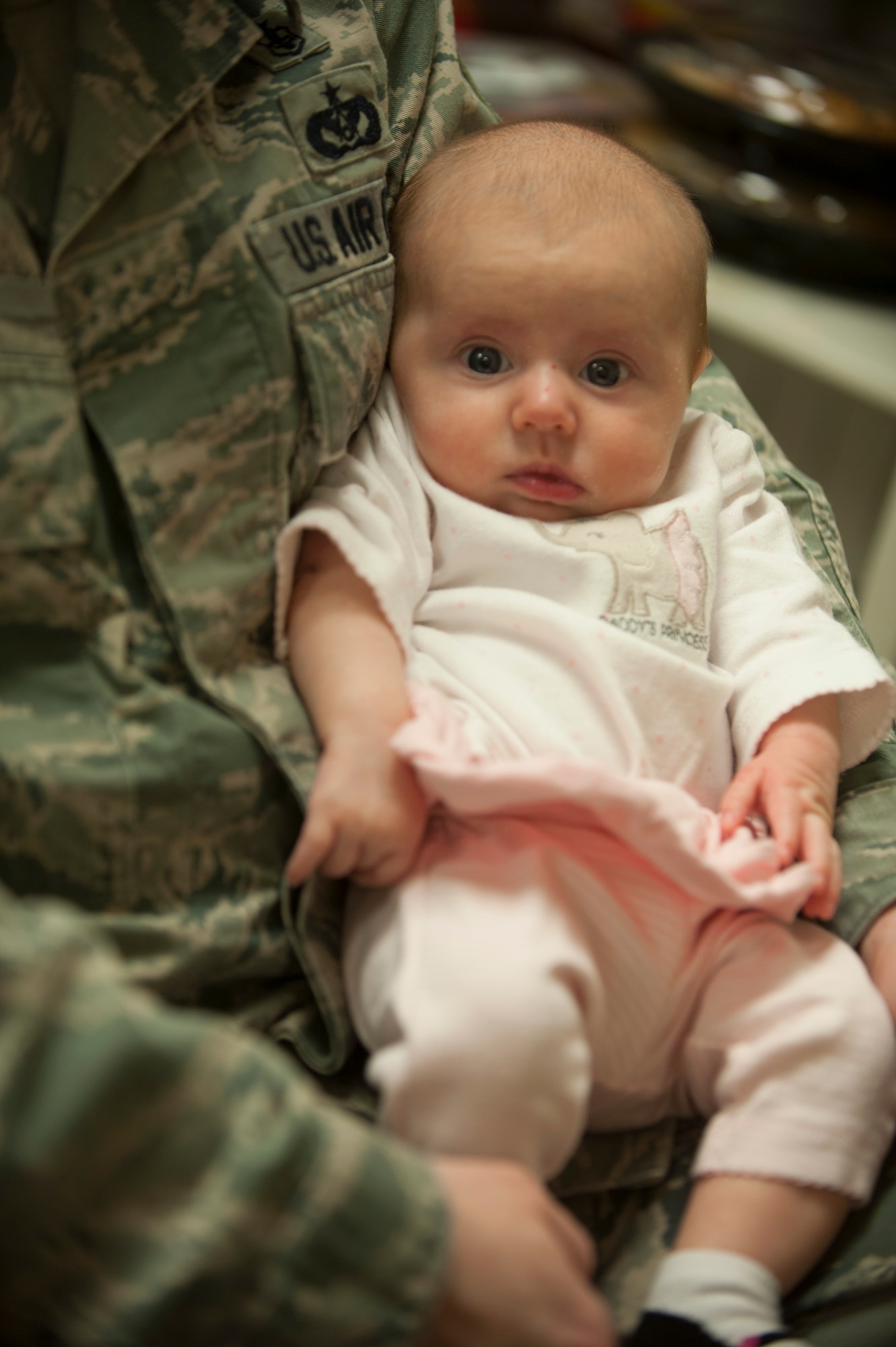 U.S. Air Force Tech. Sgt. Dustin Mize, NCO in charge of ambulance services from the 5th Medical Group, holds his daughter, Ashlyn, during a Dad’s 101 class on Minot Air Force Base, N.D., April 1, 2014. Mize brought his daughter to show first-time fathers the behaviors and functions of a newborn baby. (U.S. Air Force photo/ Airman 1st Class Sahara L. Fales)