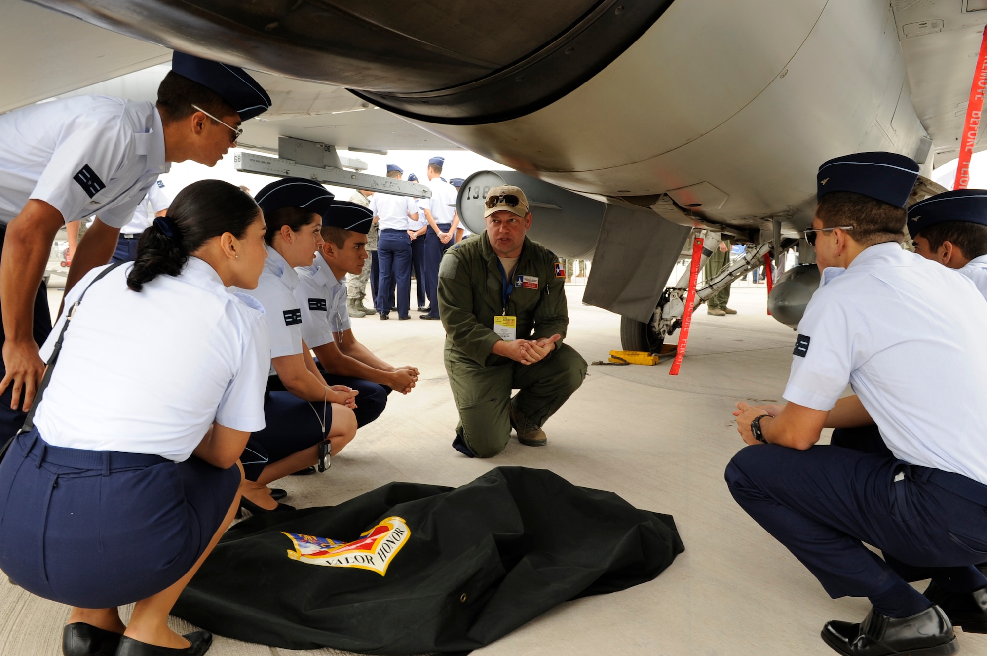 Lt. Col. Greg Pohoski, an F-16 instructor pilot with the 149th Fighter Wing, Texas Air National Guard, discusses flying operations with cadets from FACH (Fuerza Aerae de Chile), the Chilean air force, at FIDAE (Feria Internacional del Aire y del Espacio), an international trade exhibition air and space show, in Santiago, Chile, March 27, 2014. Pohoski was in Chile with members of the Texas Air National Guard for a subject matter expert exchange through the National Guard Bureau's State Partnership Program. (U.S. Air National Guard photo by Senior Master Sgt. Miguel Arellano / Released)