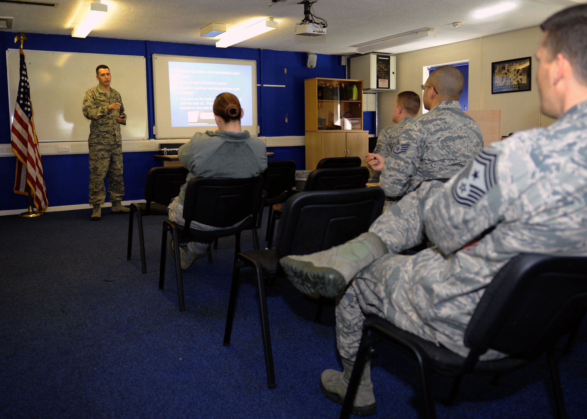 U.S. Air Force Senior Airman Tyler Adams, left, 100th Security Forces Squadron trainer from Grasslake, Mich., briefs Airmen April 8, 2014, how to properly use an infrared light radar system on RAF Mildenhall, England. U.S. Air Force Chief Master Sgt. Tracy Jones, 100th Air Refueling Wing command chief, attended the class prior to a ride along with 100th SFS Airmen as part of the Dirty Jobs program. After the class, Jones and Adams surveyed Team Mildenhall traffic for drivers breaking the speed limit. (U.S. Air Force photo by Airman 1st Class Preston Webb/Released)