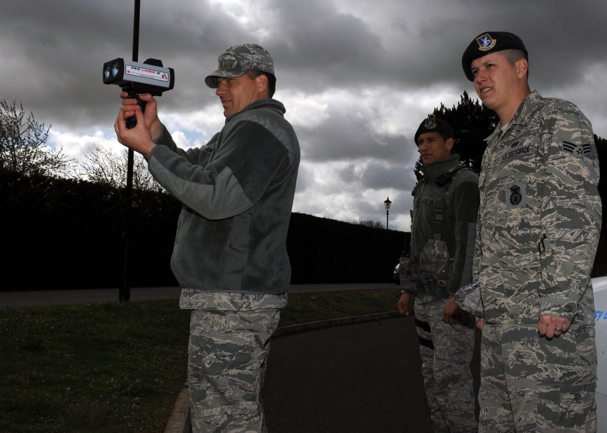 U.S. Air Force Senior Airman Tyler Adams, right, 100th Security Forces Squadron trainer from Grasslake, Mich., and U.S. Air Force Senior Airman Angel Trejo, 100th SFS patrolman from Fresno, Calif., chaperone U.S. Air Force Chief Master Sgt. Tracy Jones, 100th Air Refueling Wing command chief, as he identifies speeding vehicles April 8, 2014, on RAF Mildenhall, England. Jones rode along with Trejo and Adams as part of the Dirty Jobs program and encouraged Team Mildenhall members to drive safely. (U.S. Air Force photo by Airman 1st Class Preston Webb/Released)