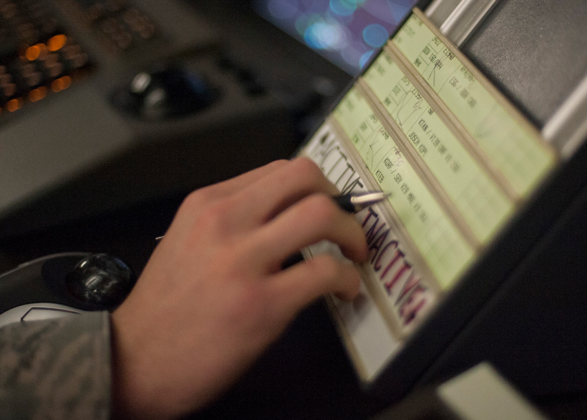 A controller checks a strip holder for accurate information April 2, 2014, at Dover Air Force Base, Del. Both tower and radar approach controllers use strips to hold information about an aircraft such as name, type of aircraft, approach or its flight route. (U.S. Air Force photo/Senior Airman Jared Duhon)