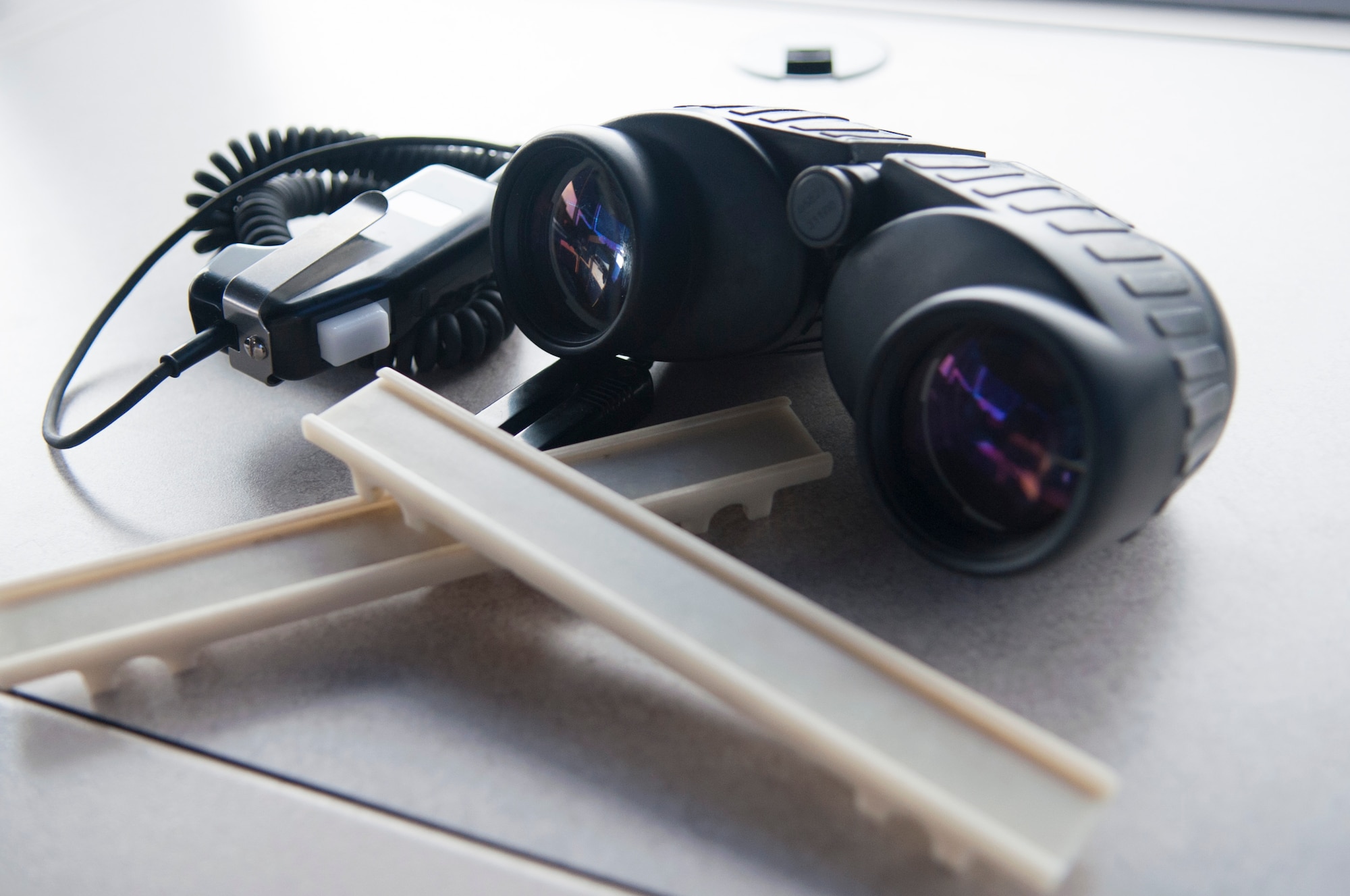 A headset, strip holders and binoculars sit on a table in the air traffic control tower April 2, 2014, at Dover Air Force Base, Del. The headset and strip holders are common tools used by both tower and radar approach control ATC facilities personnel. (U.S. Air Force photo/Senior Airman Jared Duhon)