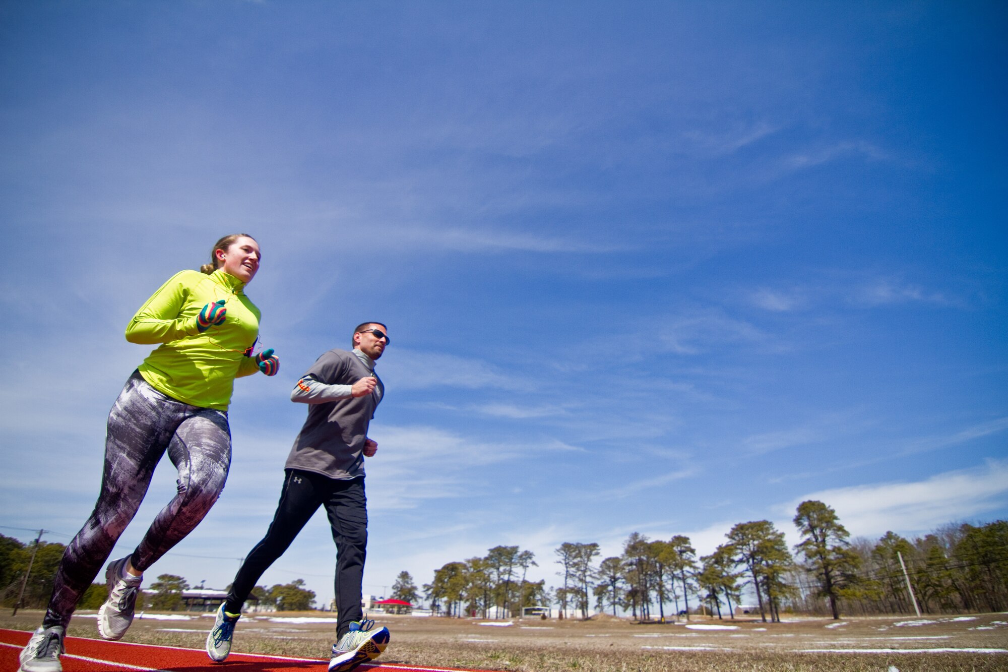A picture of U.S. Air Force Staff Sgt. Alison Jones and Tech. Sgt. Joseph Iovanisci running at the 177th Fighter Wing track.