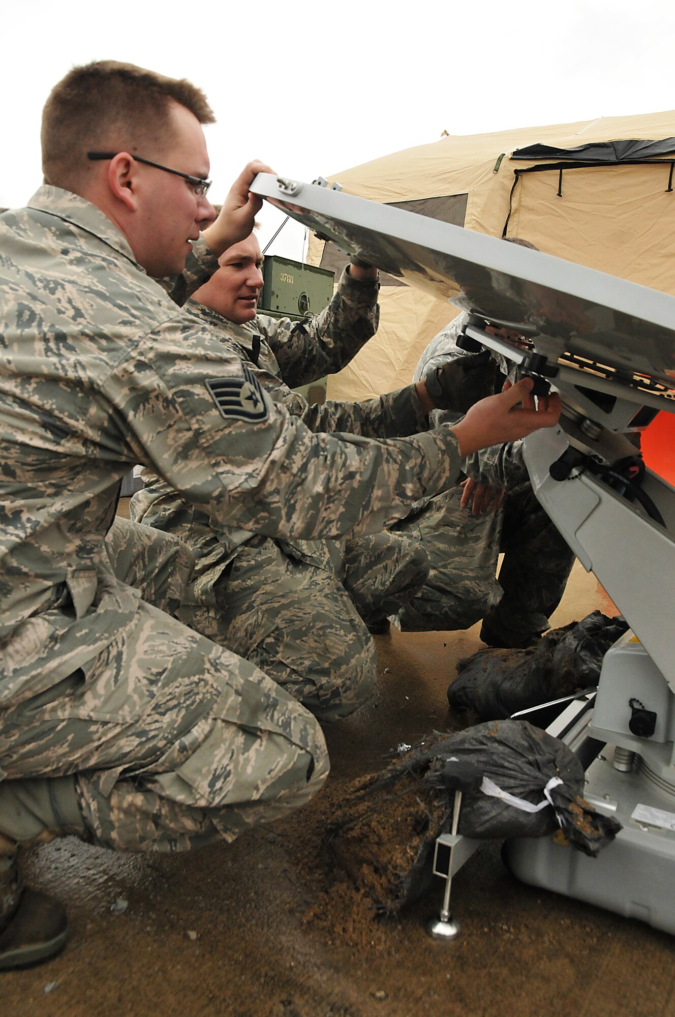Staff Sgt. Joseph Davis (left) and Master Sgt. Nathan Lukey, members of the Joint Incident Sight Communications Capability Team, assemble a mobile satellite to ensure communications during a 50-hour exercise at Springfield Air National Guard Base that showcased the base’s unique capabilities for incident awareness and assessment during domestic disasters, April 4-5. (U.S. Air National Guard Photo by Tech. Sgt. Lou Burton)