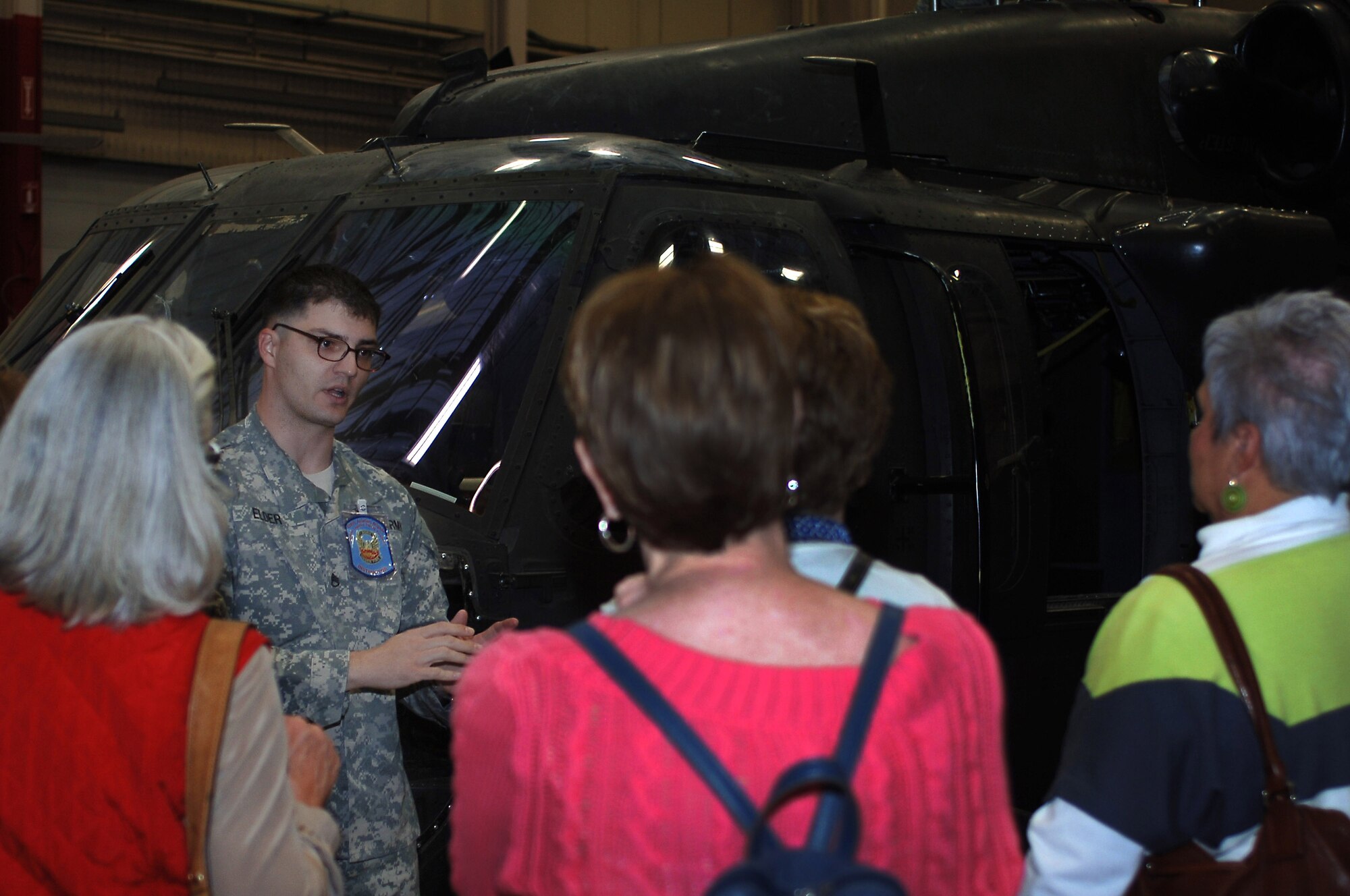 U.S. Army Staff Sgt. Christopher Elder, 2nd Battalion, 210th Aviation Regiment instructor, leads members of the Williamsburg Area Chamber and Tourism Alliance Community Leadership Service program on a tour of a UH-60 Black Hawk helicopter trainer model during an installation tour at Fort Eustis, Va., April 1, 2014. During the tour, visitors received a presentation on the many missions performed by various units on the installation. (U.S. Air Force photo by Senior Airman Teresa J.C. Aber/Released)