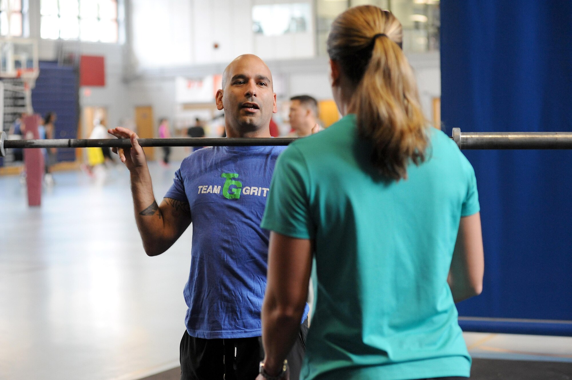 U.S. Marine Corps Gunnery Sgt. Juan Ospina, Joint Task Force Civil Support operations noncommissioned officer in charge, demonstrates proper physical technique for an overhead squat during a CrossFit session held at the Anderson Field House at Fort Eustis, Va., March 19, 2014. Ospina is the JTF-CS physical training promotion coordinator and the lead Fort Eustis CrossFit instructor. He believes physical fitness enhances unit readiness by promoting team cohesion and mental alertness. (Department of Defense photo by U.S. Air Force Tech. Sgt. Gwendolyn Blakley/Released)
