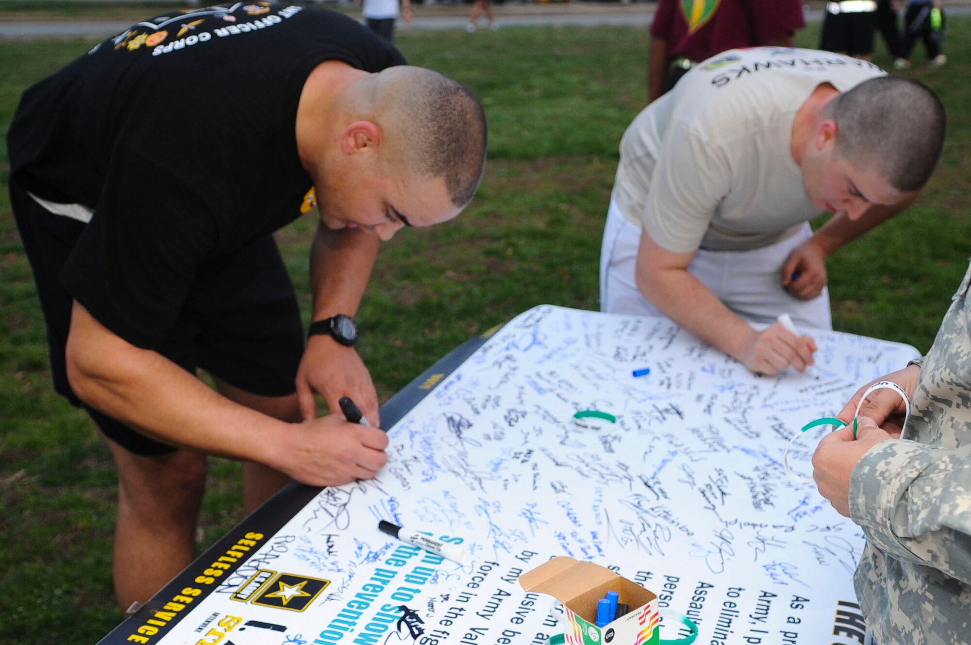 Runners sign a Sexual Assault Awareness Month banner during a Sexual Assault Awareness Month 5K run at Fort Eustis, Va., April 4, 2013. The 5K is one of many events SAAM personnel will hold to promote the battle buddy mentality and prevent sexual assaults in the Army. (U.S. Air Force photo by Senior Airman Austin Harvill/Released) 