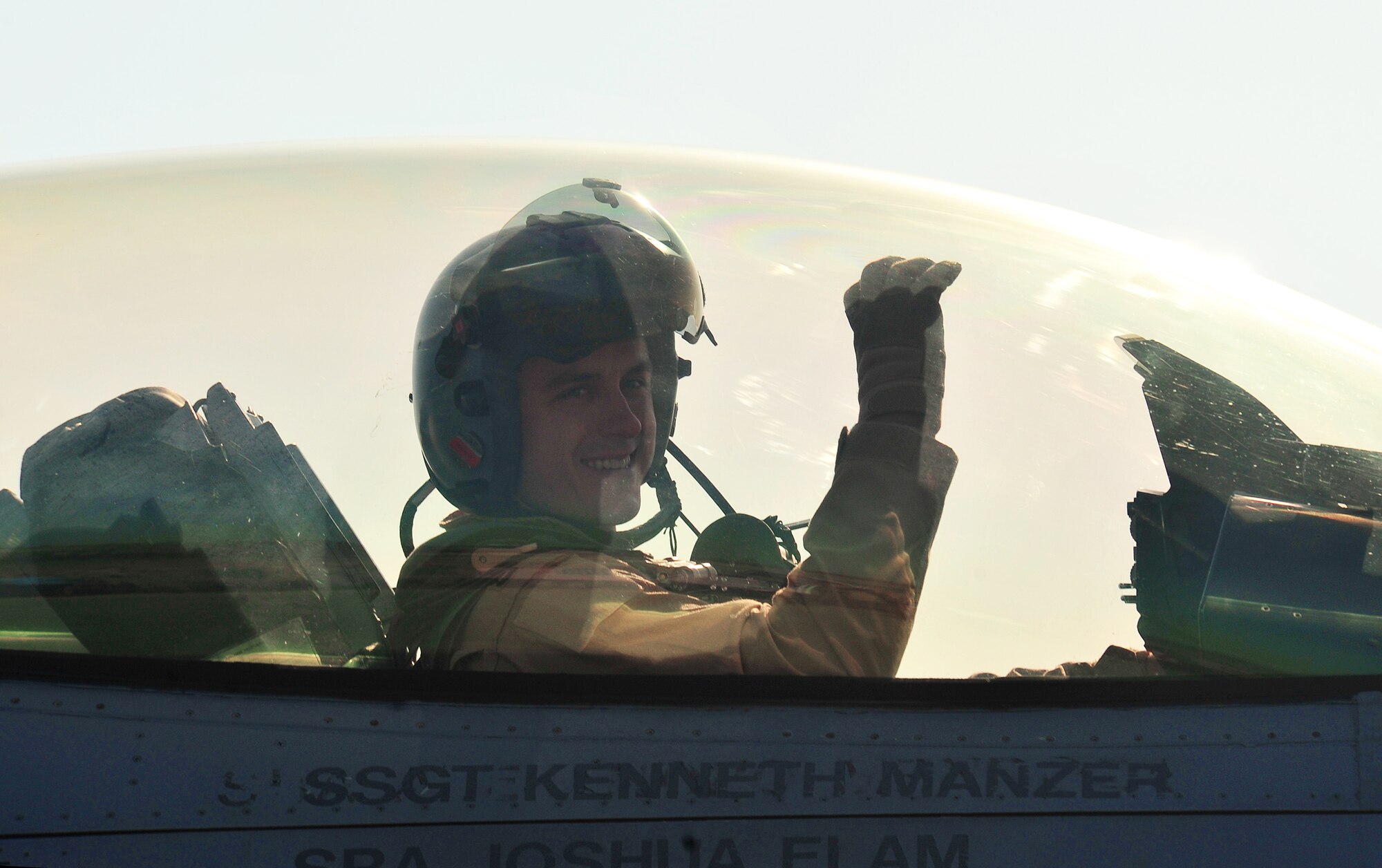 An F-16 Fighting Falcon pilot from the 13th Fighter Squadron raises his hand in the form of a panther claw, the squadron signature gesture, at family members and friends as he readies for departure at Misawa Air Base, Japan, April 8, 2014. Members of his squadron, along with family and friends, had the opportunity to wave their last goodbyes to the team of Wild Weasels headed for deployment abroad. (U.S. Air Force photo/Senior Airman Jose L. Hernandez-Domitilo)