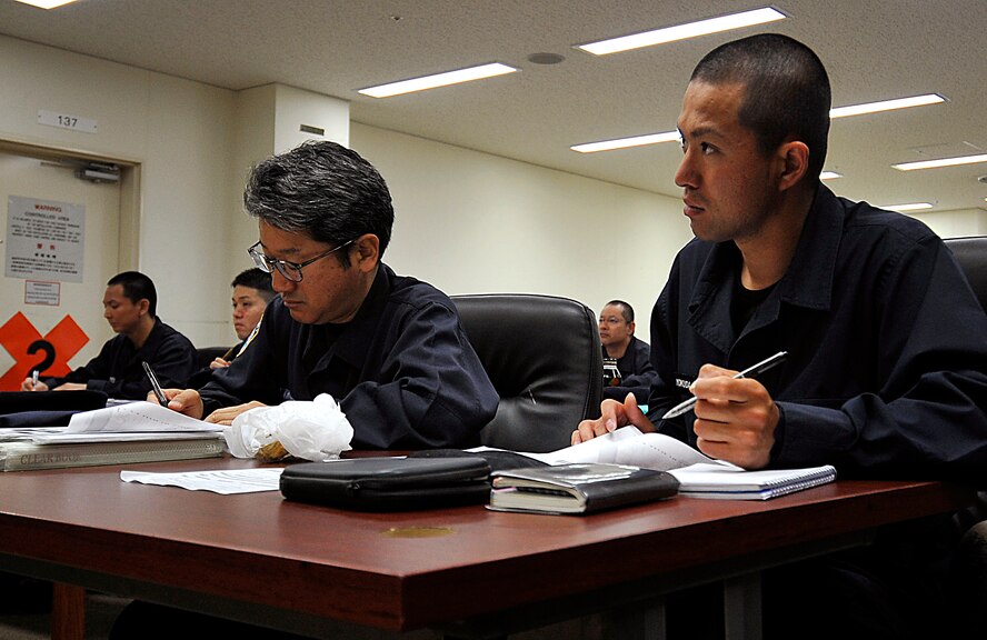 Itsuki Yokuda, 18th Security Forces Squadron guard, takes notes during a monthly training session on Kadena Air Base, Japan, March 31, 2014. Approximately 50 civilian guards and patrolmen took a Traffic Accident Response Procedure class held on three separate days. The training, which is the first of its kind, is intended to teach civilian guards and patrolmen how to process accidents, improve their skills and prepare them for future contingencies. (U.S. Air Force photo by Naoto Anazawa)
