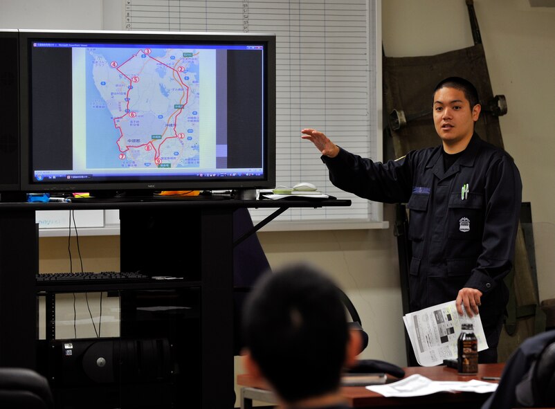 Yoshikazu Isa, 18th Security Forces Squadron master labor contractor and training instructor, explains the off-base area of jurisdiction during a monthly training session on Kadena Air Base, Japan, March 31, 2014. The off-base area of jurisdiction is divided among the U.S. Marines, U.S. Army and U.S. Air Force. Civilian guards and patrolmen must also perform as interpreters if Japanese citizens are involved in traffic accidents off-base. (U.S. Air Force photo by Naoto Anazawa)