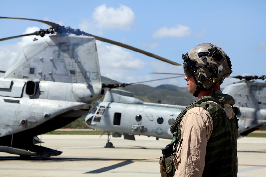 Marine Corps Gunnery Sgt. Christopher L. Hawley supervises preflight checks of a CH-46E Sea Knight helicopter on Camp Pendleton, Calif., March 31, 2014. Hawley is a crew chief assigned to Marine Medium Helicopter Squadron 364, Marine Aircraft Group 39, 3rd Marine Aircraft Wing. After 47 years of flying the CH-46, members of the squadron take off, fly in formation and land in unison, signifying the transition to the MV-22 Osprey.