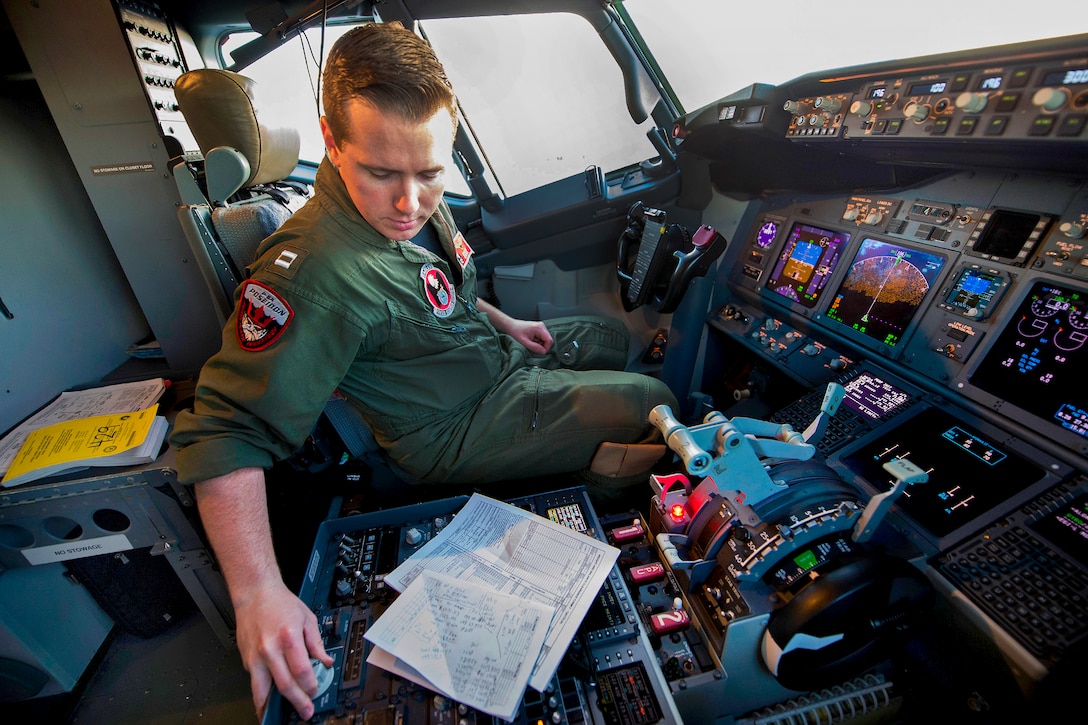 U.S. Navy Lt. Kenneth Savage performs preflight checks in the flight station of a P-8A Poseidon aircraft on the flight line at Perth Airport, Australia, April 4, 2014, before taking off to assist in the search for Malaysia Airlines Flight 370. Savage is an naval aviator assigned to Patrol Squadron 16.