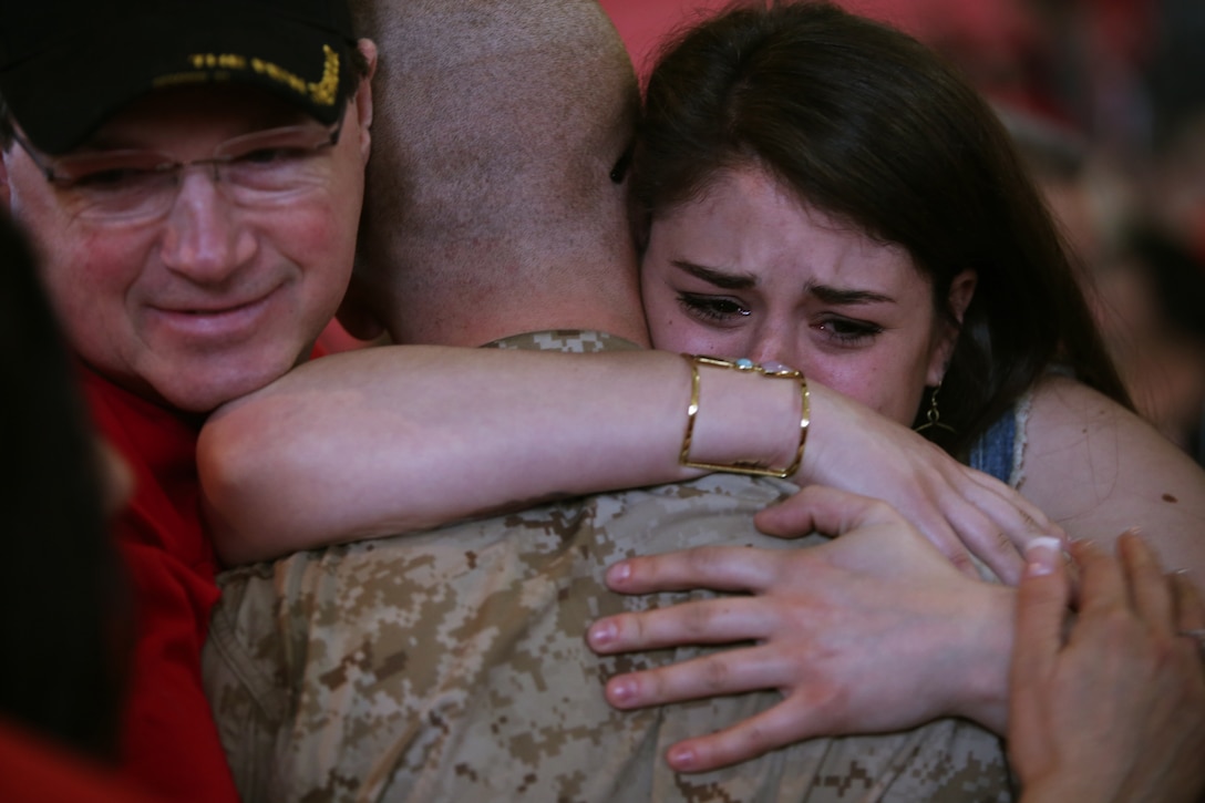 Family members embrace their new Marine of Charlie Company, 1st Recruit Training Battalion, following the Family Day ceremony April 3, 2014, on Parris Island, S.C. The Marines spent nearly three months training to earn their places in the Corps. Charlie Company graduated April 4, 2014. (Photo by Cpl. Octavia Davis)