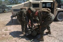 Hospital corpsmen with 2nd Medical Battalion, Combat Logistics Regiment 25, 2nd Marine Logistics Group lay a Marine with a simulated injury on a stretcher during a medical field exercise aboard Camp Lejeune, N.C., April 2, 2014. Service members worked with simulated casualties instead of training dummies to help them understand not only how to treat injuries, but the nature of the medical emergencies themselves.