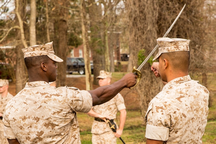 An instructor with the 2nd Marine Logistics Group’s Corporal’s Course assists a noncommissioned officer with sword drill movements aboard Camp Lejeune, N.C., March 20, 2014. Instructors used a combination of demonstration and repetitive application to hone the Marines’ form and command presence.