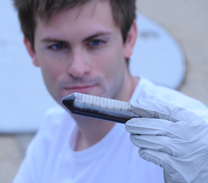Blake Stamps, University of Oklahoma student, inspects a contaminant from a fuel tank on Barksdale Air Force Base, La., April 2, 2014. The Air Force Research Lab at Wright-Patterson Air Force Base, Ohio, teamed with Dr. Bradley Stevenson's laboratory at the University of Oklahoma to conduct surveys of storage tanks at various bases around the country and determine what types of microorganisms create biofilms in storage tanks and which materials are at risk for bio-deterioration. (U.S. Air Force photo/Staff Sgt. Jason McCasland)