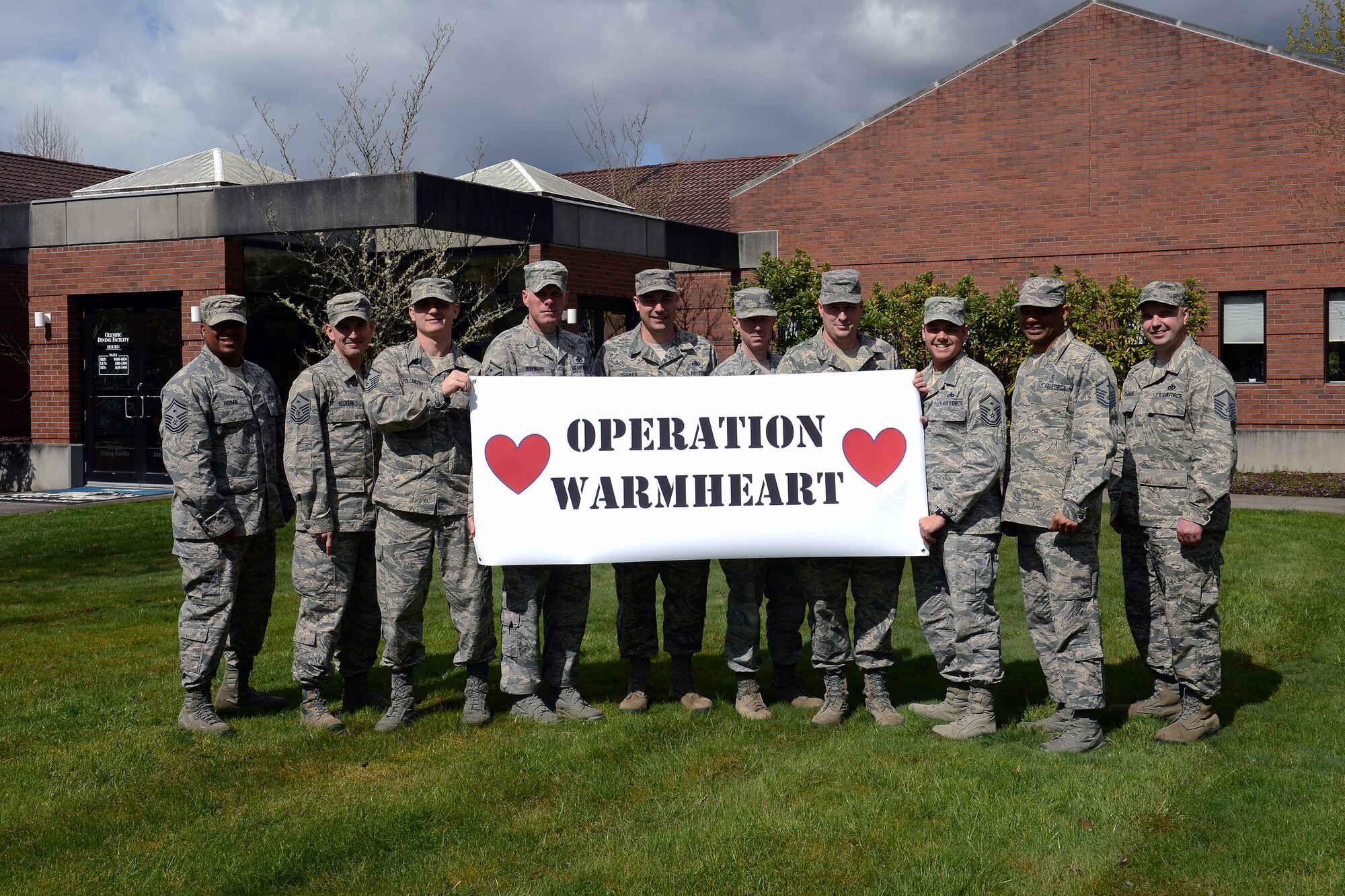 Team McChord first sergeants pose for a photo after passing out gift cards to Airmen as part of Operation Warmheart at the Olympic Dining Facility, April 9, 2014, at Joint Base Lewis-McChord, Wash. As part of Operation Warmheart, Team McChord first sergeants facilitated the event to show support to young Airmen. (U.S. Air Force photo by Airman First Class Jacob Jimenez)      